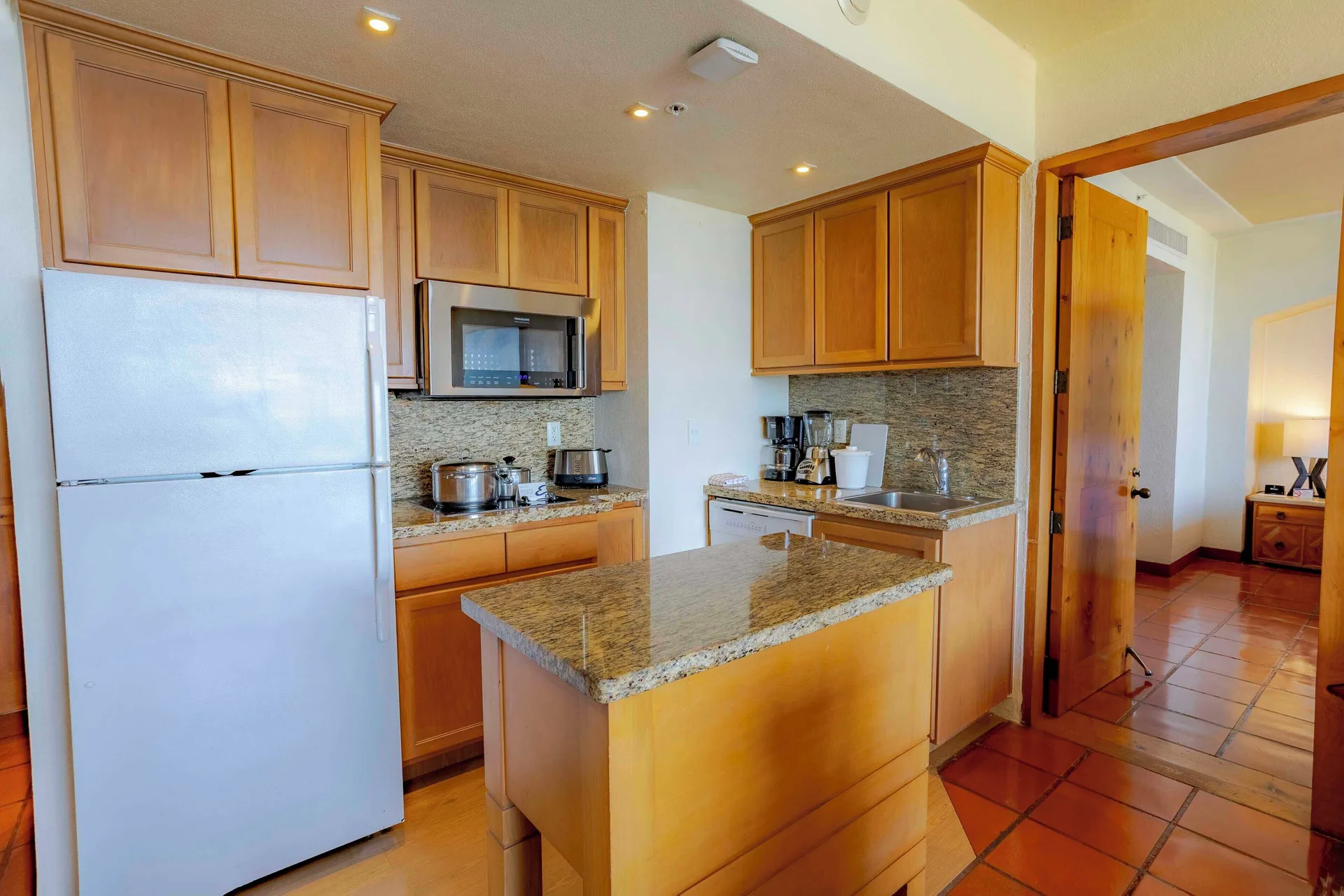 Suite kitchen with wood cabinets and granite island at Club Regina Puerto Vallarta.