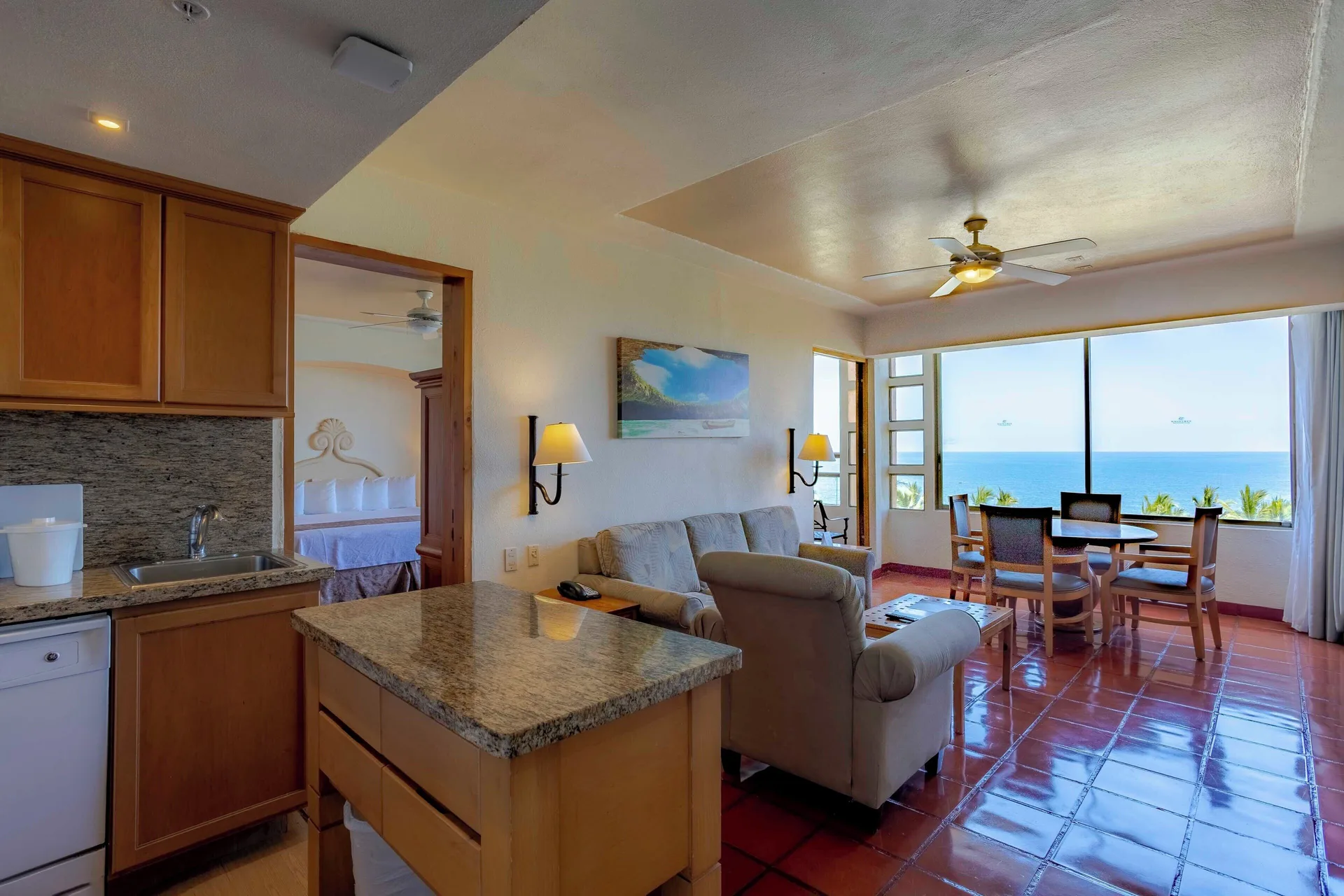 Ocean view suite living room with kitchen and bedroom doorway at Club Regina Puerto Vallarta.