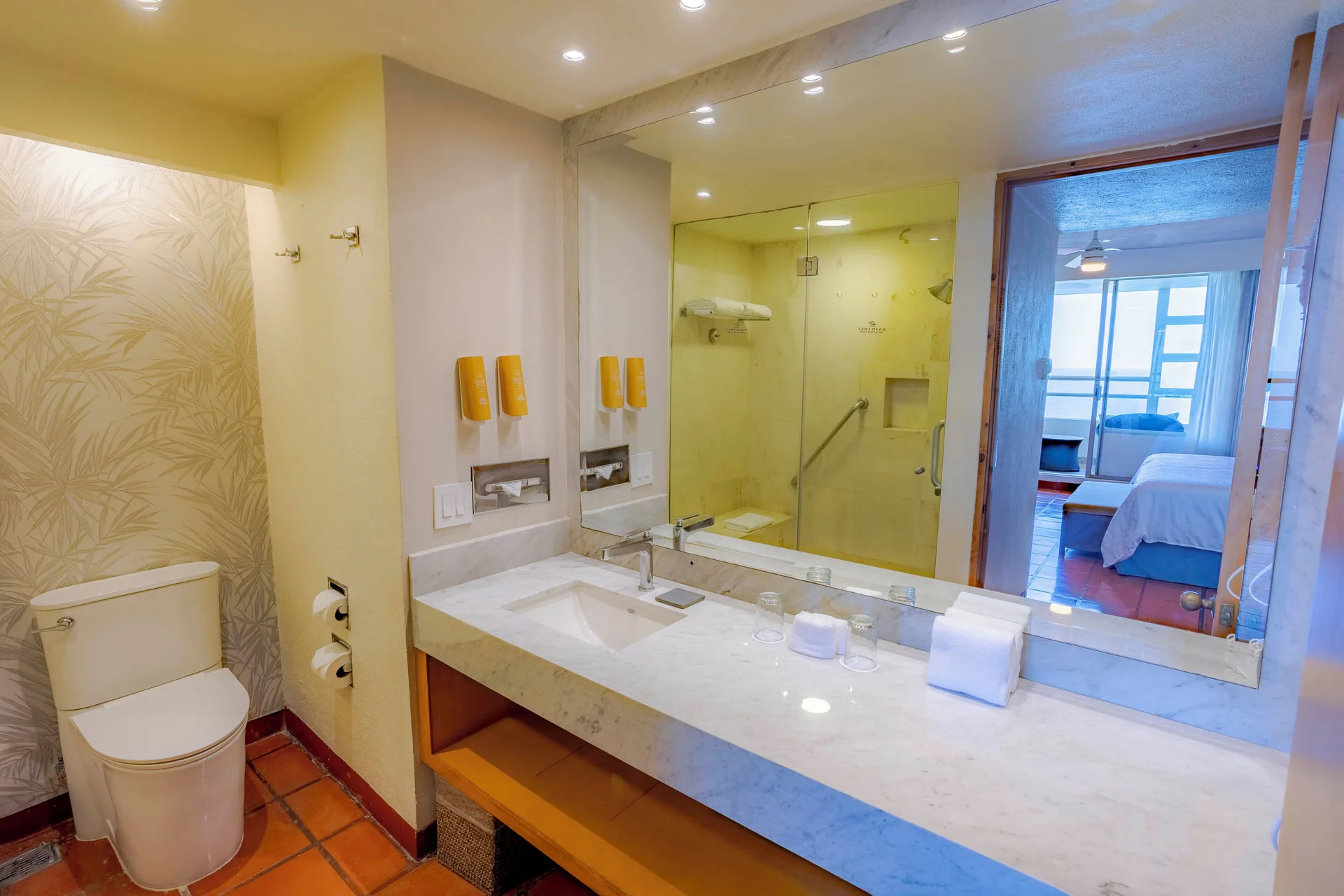Suite bathroom vanity and shower at Club Regina Puerto Vallarta, with the bedroom visible beyond.