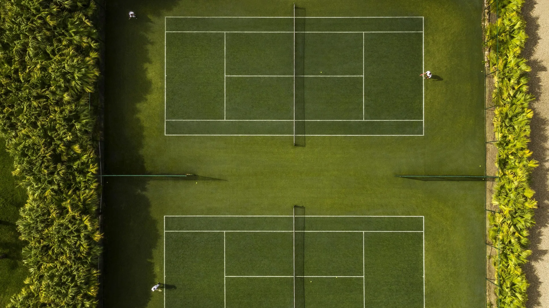 Two tennis courts are viewed from above at COMO Parrot Cay.