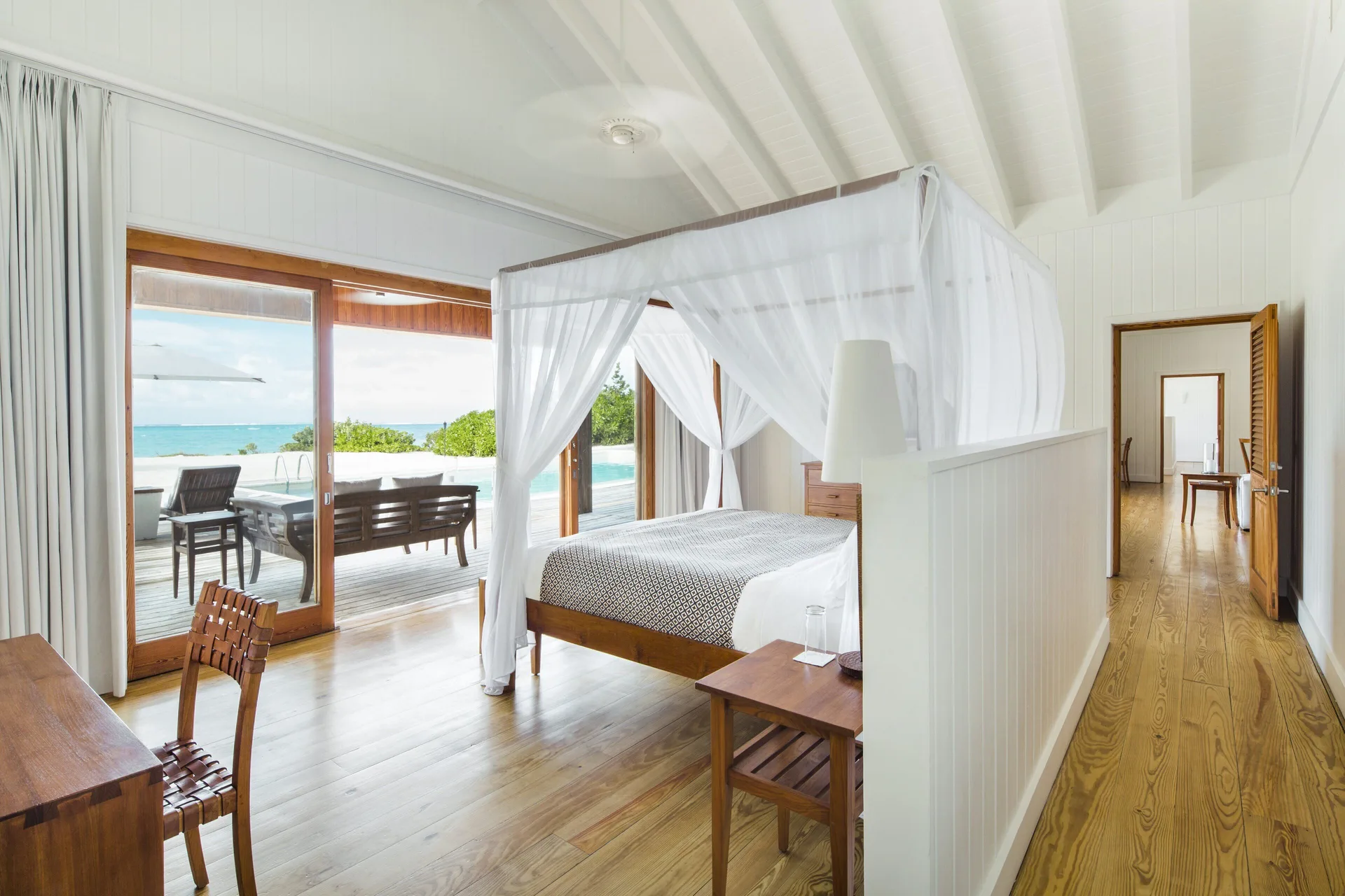 Four-poster bedroom opening to a pool terrace at COMO Parrot Cay.