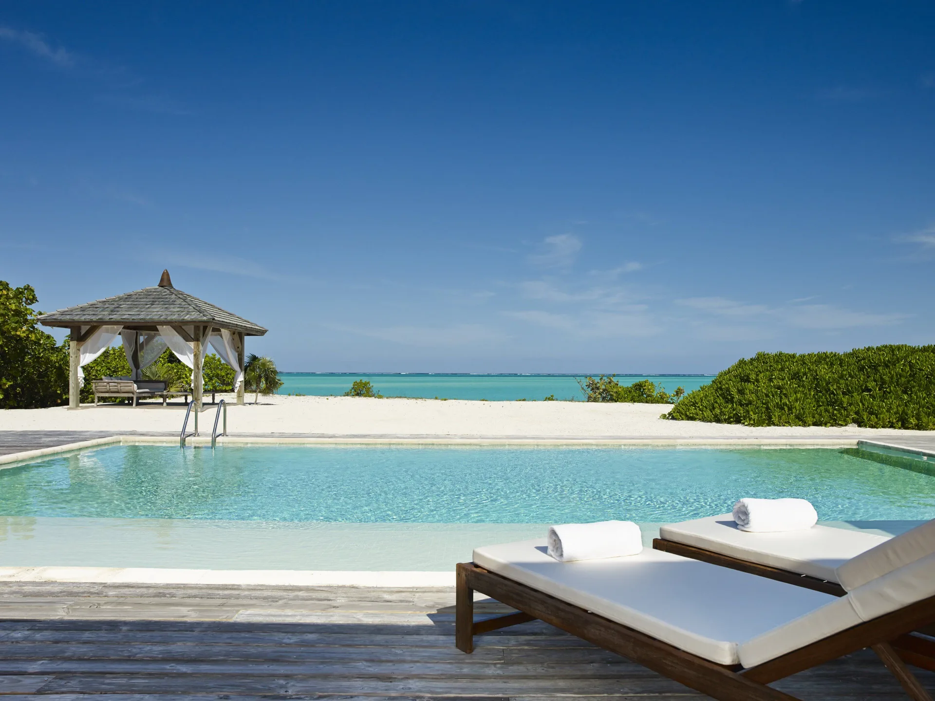Beach House pool, loungers and ocean view at COMO Parrot Cay.