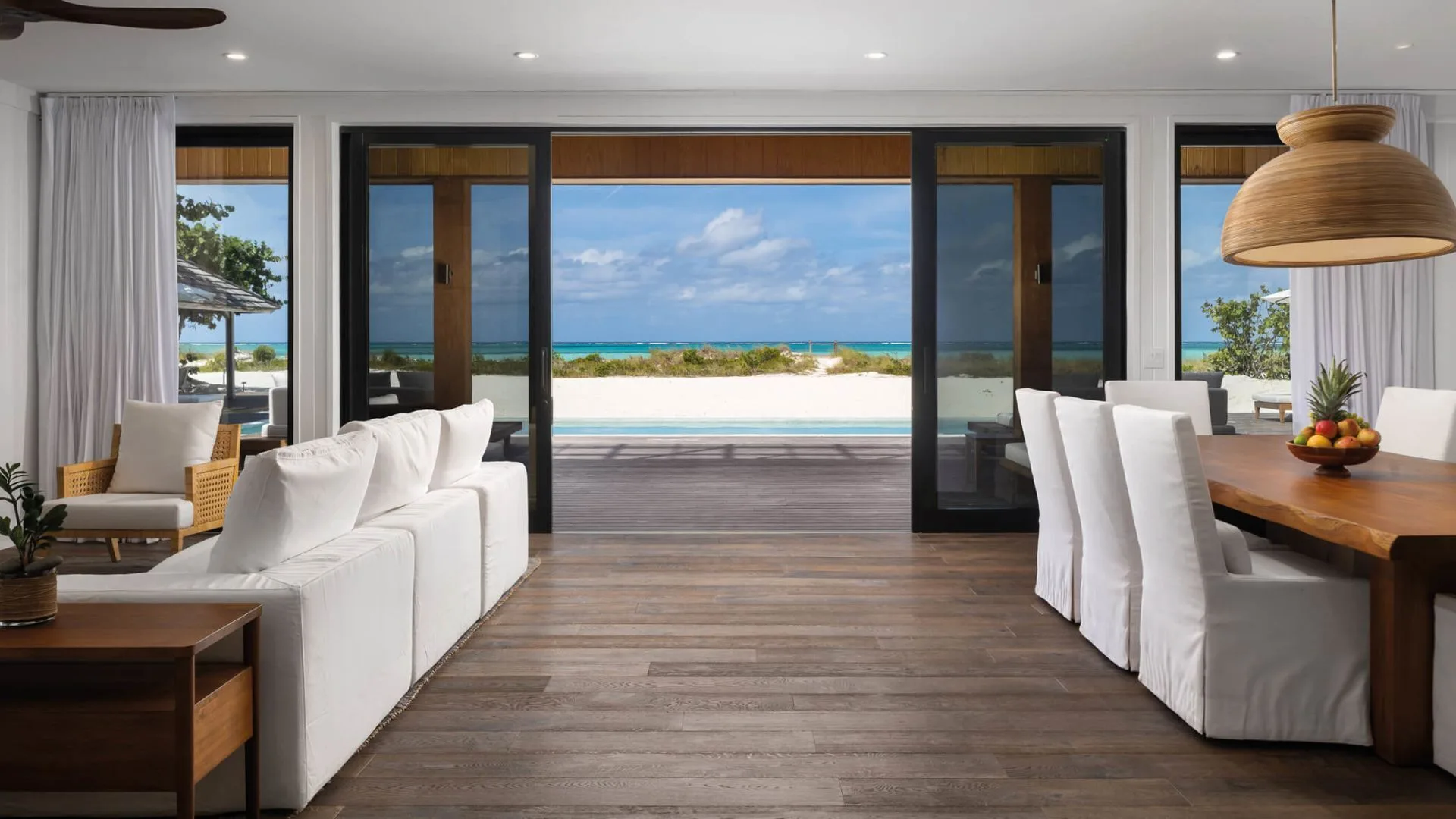 Como Villa living and dining room with beach and pool views at COMO Parrot Cay.