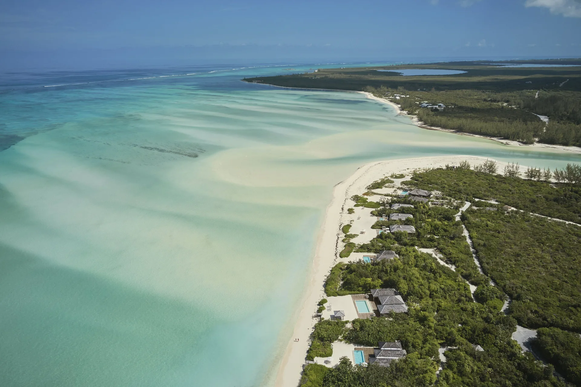 Aerial view of beach houses along the lagoon at COMO Parrot Cay.