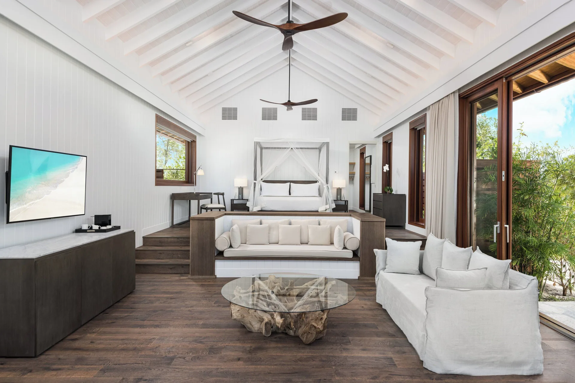 House beach living room with raised canopy king bed at COMO Parrot Cay.