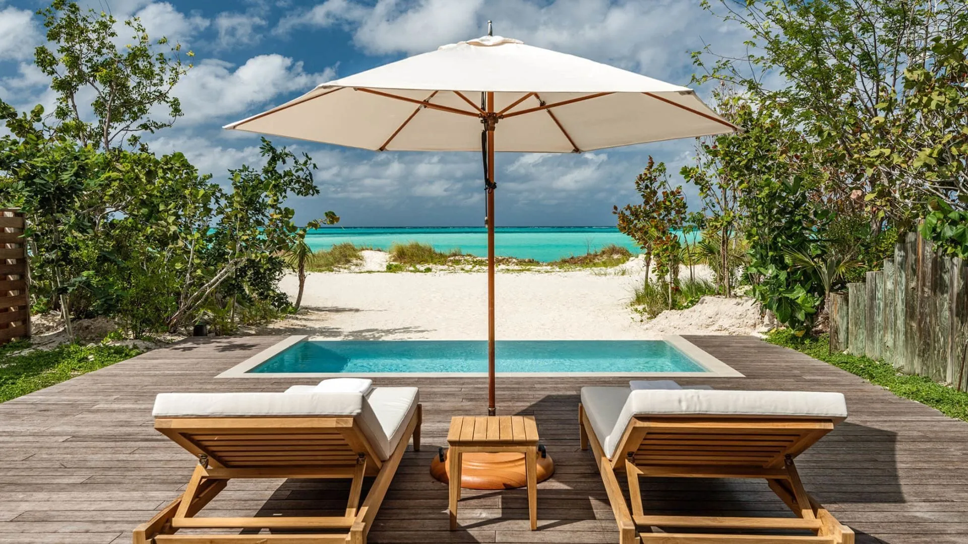 Beachfront Suite deck with loungers, pool, beach and sea at COMO Parrot Cay.