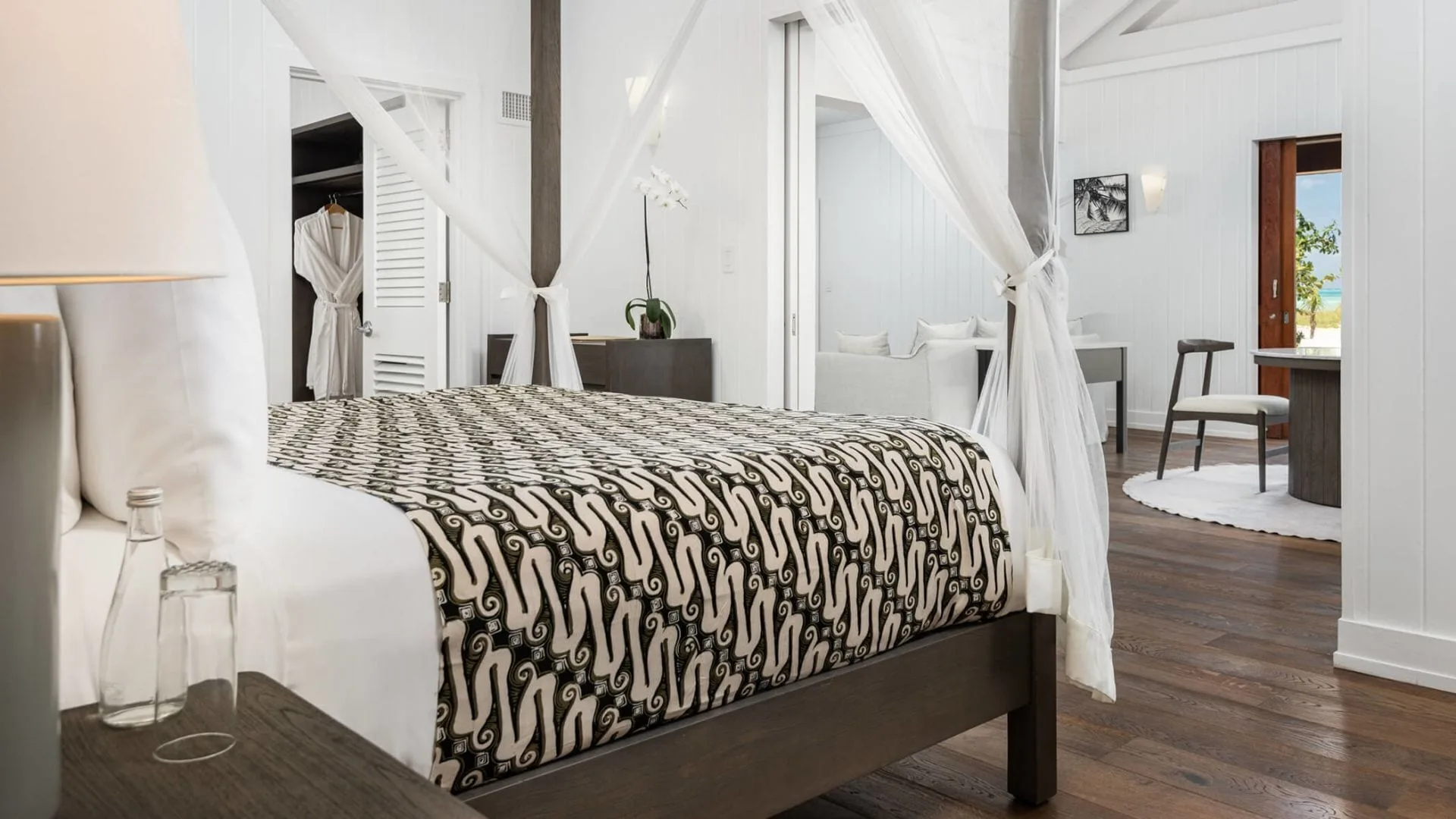 Beachfront Suite bed with patterned cover and sitting area at COMO Parrot Cay.