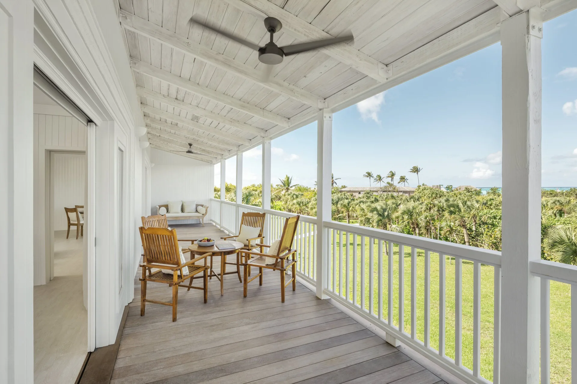 COMO Parrot Cay balcony with wooden chairs and palm views at COMO Parrot Cay.