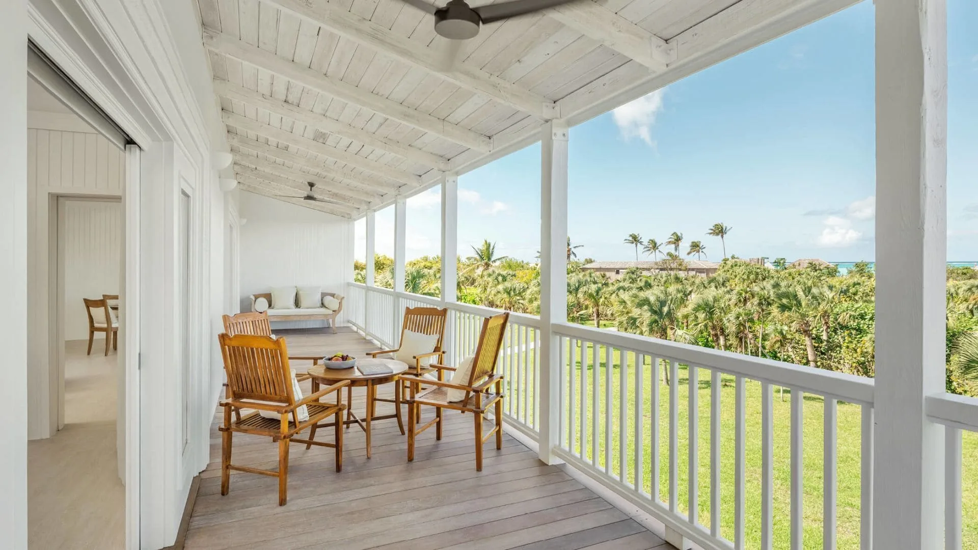 COMO Parrot Cay furnished balcony with chairs, bench and ocean glimpse at COMO Parrot Cay.