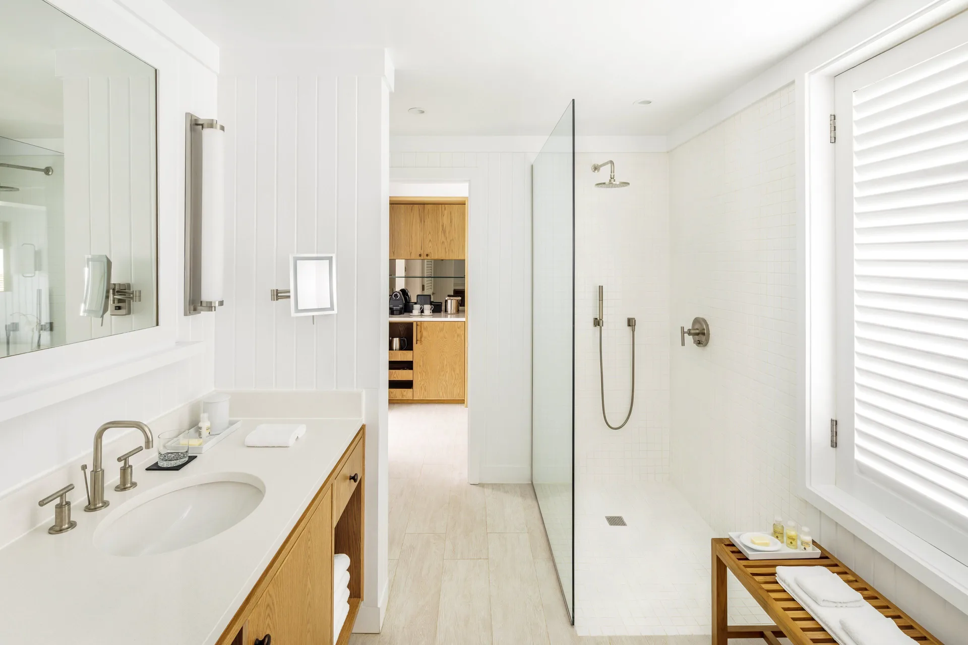 Terrace Room bathroom at COMO Parrot Cay with vanity, glass shower, and louvered window.