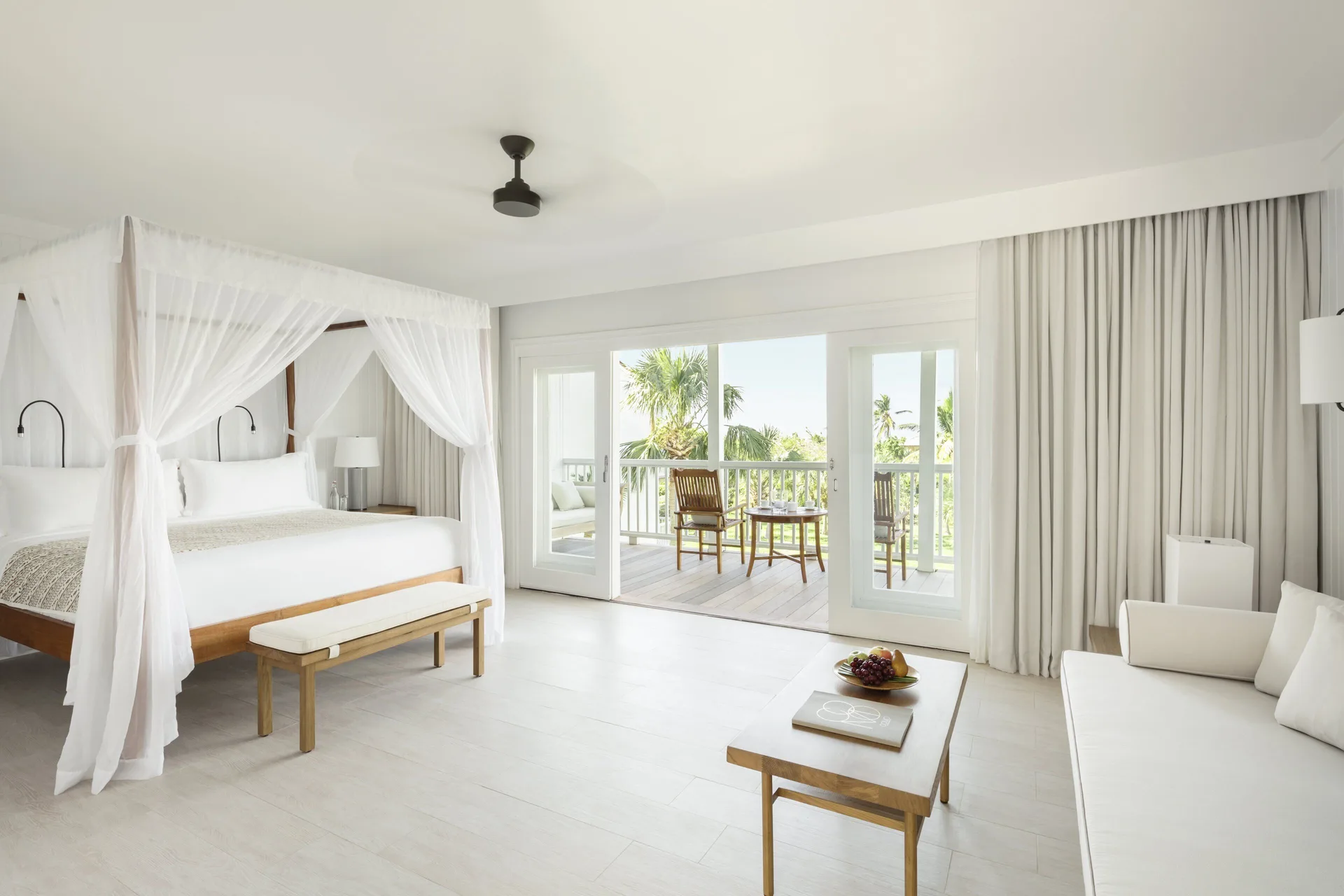 Terrace Room at COMO Parrot Cay with canopy bed, sofa, coffee table, and balcony doors.