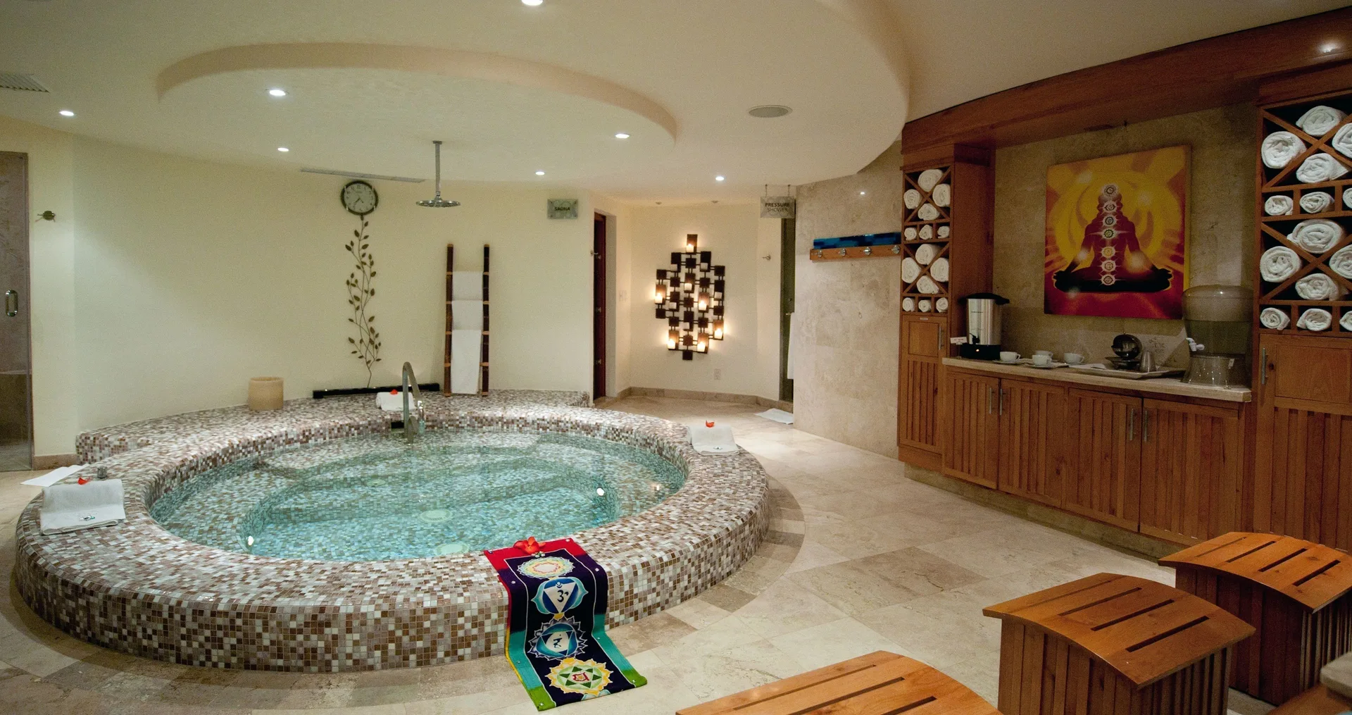 Indoor spa pool with towels, benches, and beverage station at Corazón Cabo.
