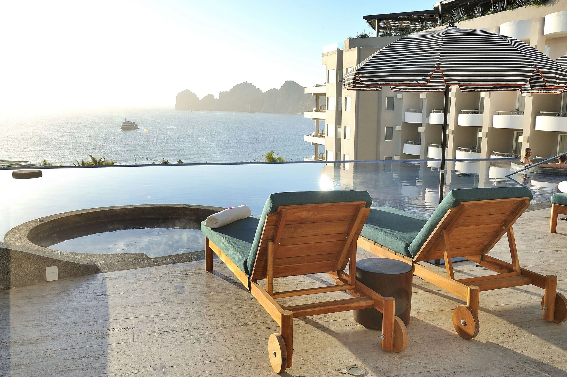 Infinity pool loungers and round spa pool overlooking the ocean at Corazón Cabo.
