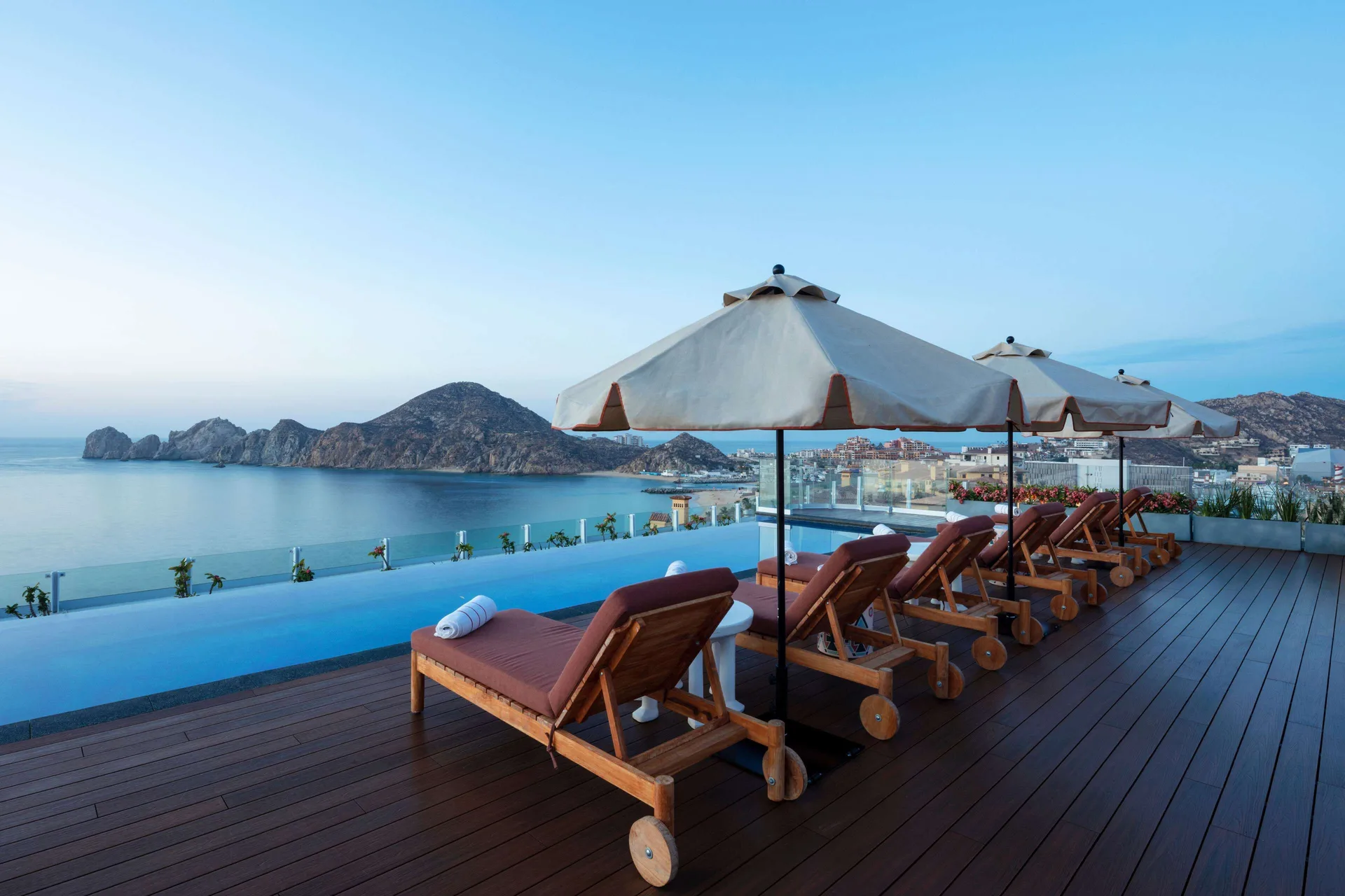Rooftop infinity pool deck with loungers overlooking the bay at Corazón Cabo.