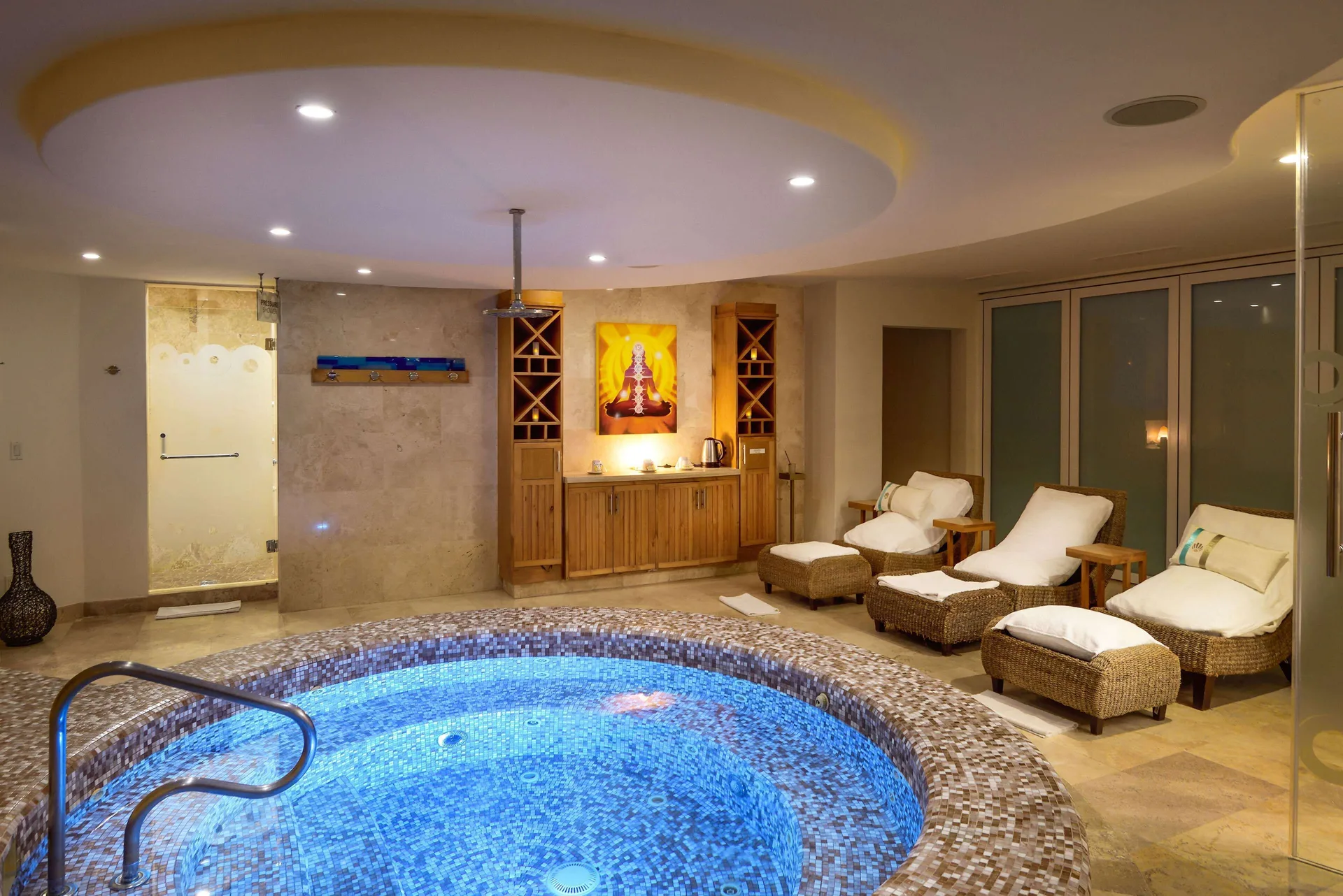 Indoor spa whirlpool with lounge chairs and a shower at Corazón Cabo.