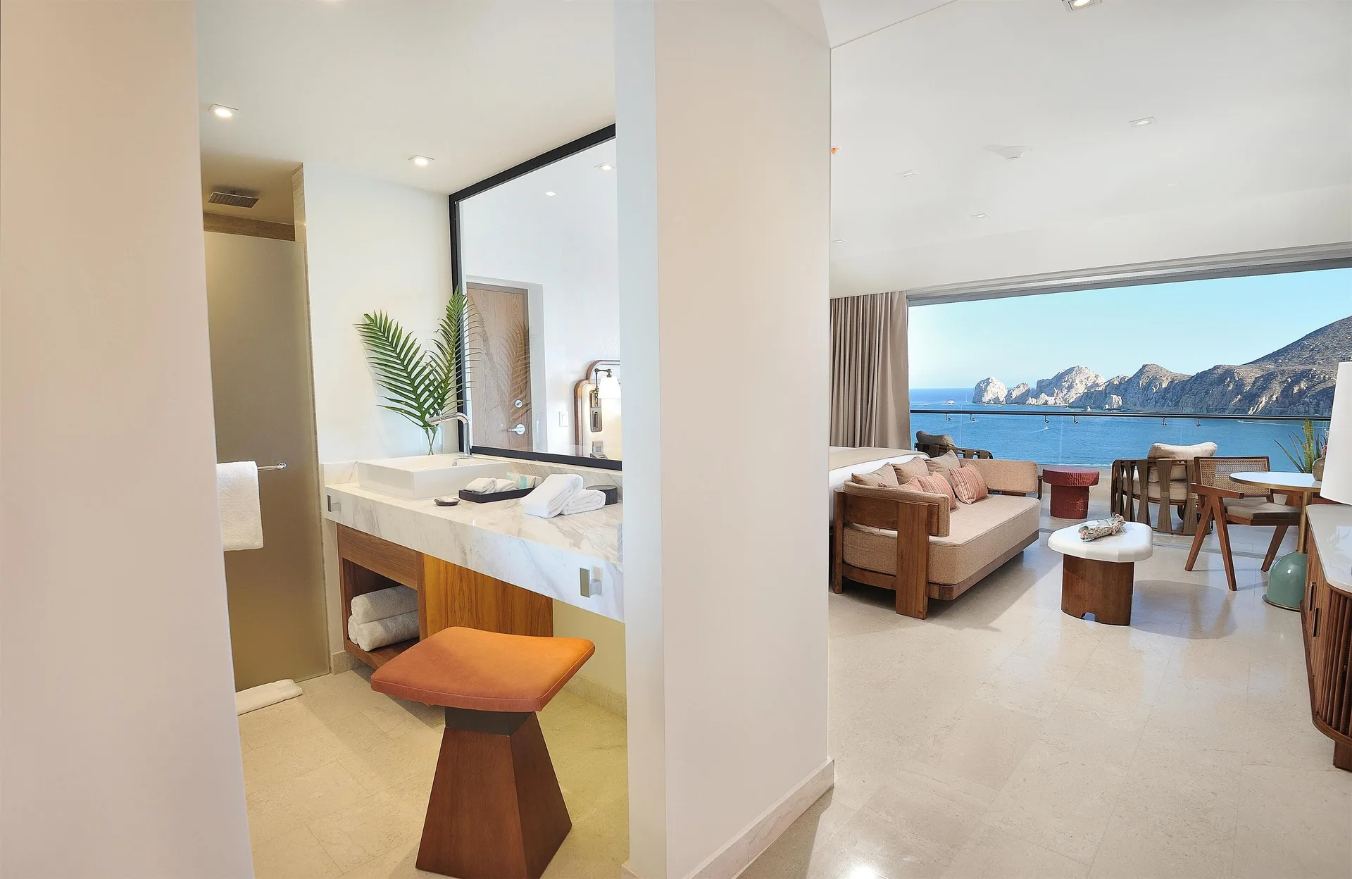 Infinity Ocean View room entry with vanity, sitting area, and bay view at Corazón Cabo.
