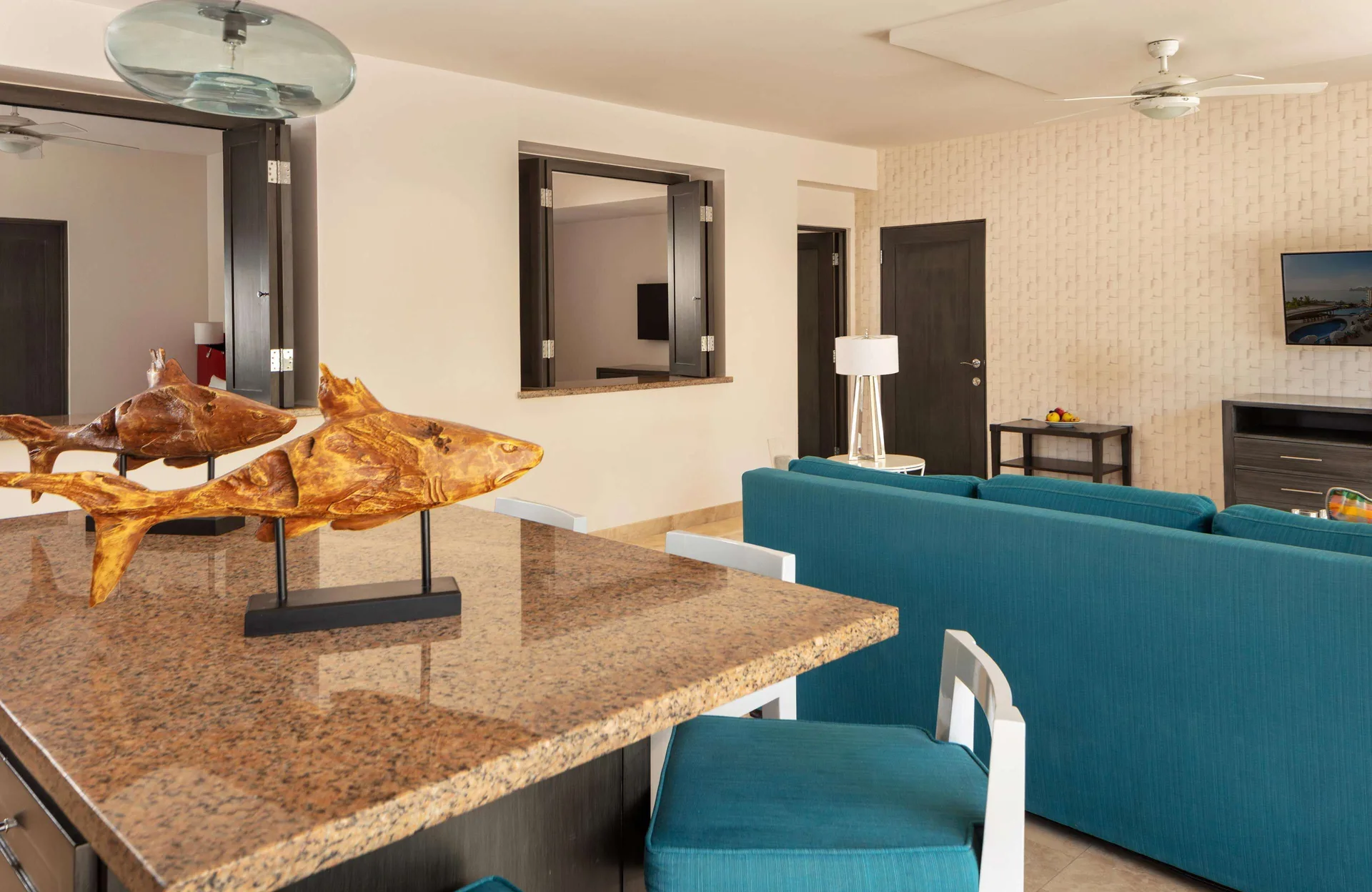Living area with turquoise sofa and granite bar in a Luxury Suite, 2 Bedrooms at Corazón Cabo.
