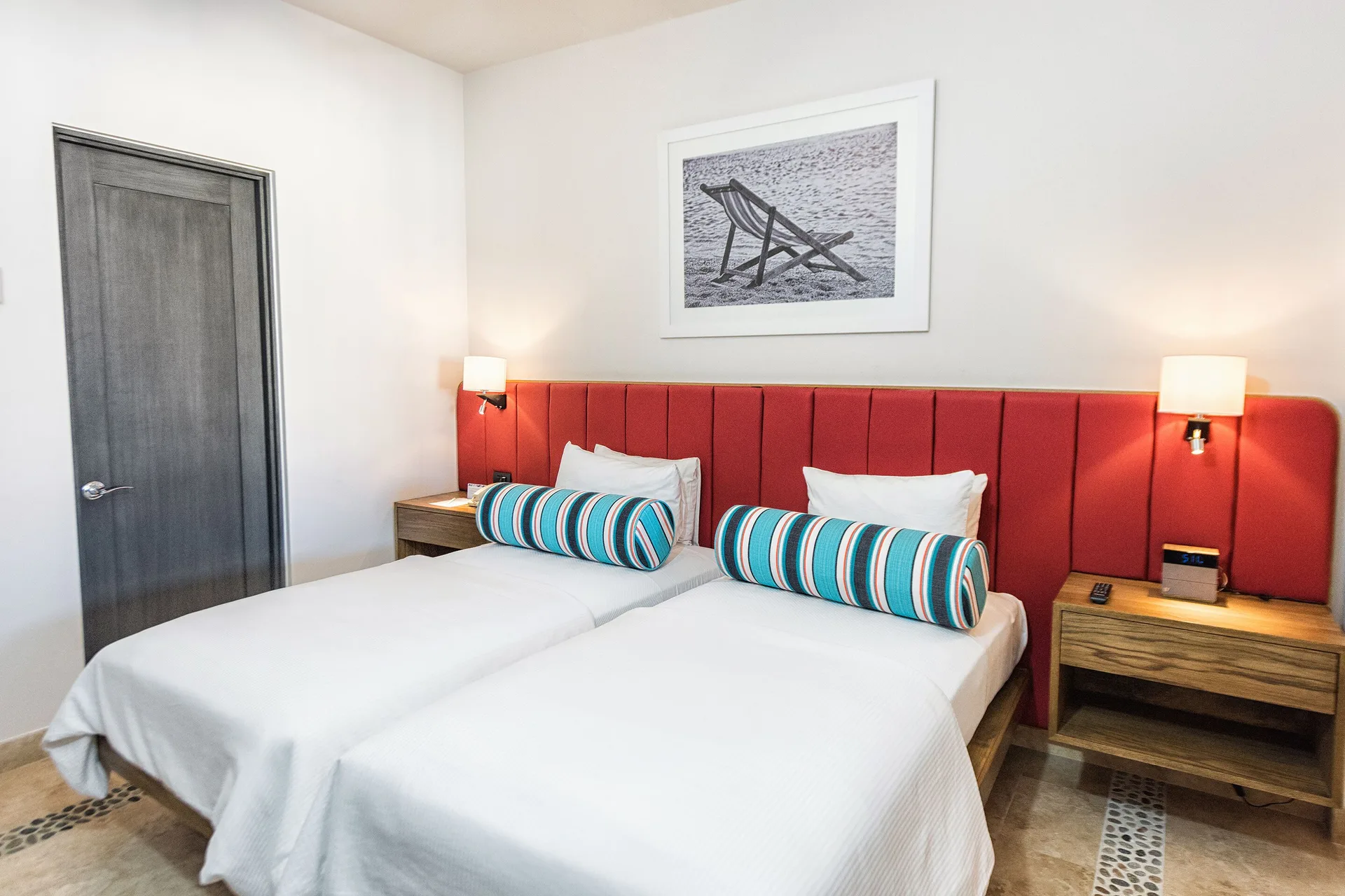 Twin beds with red headboard in a Luxury Suite, 2 Bedrooms at Corazón Cabo.