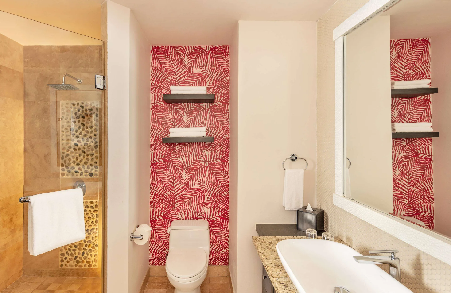 One Bedroom Deluxe bathroom with shower, vanity, and red patterned wall at Corazón Cabo.