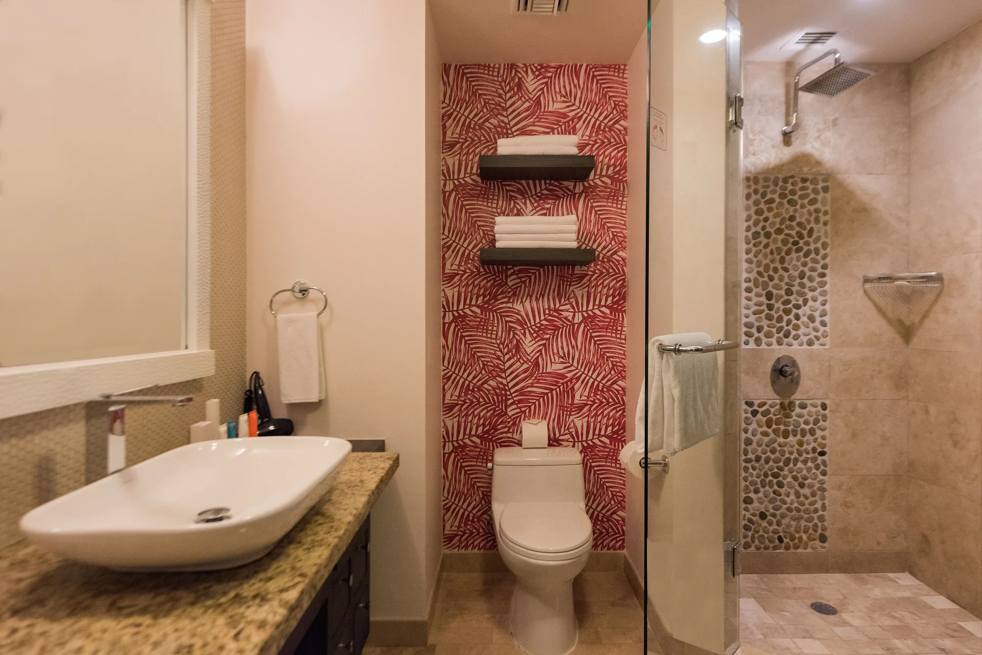 One Bedroom Deluxe bathroom with vanity, toilet, and glass shower at Corazón Cabo.