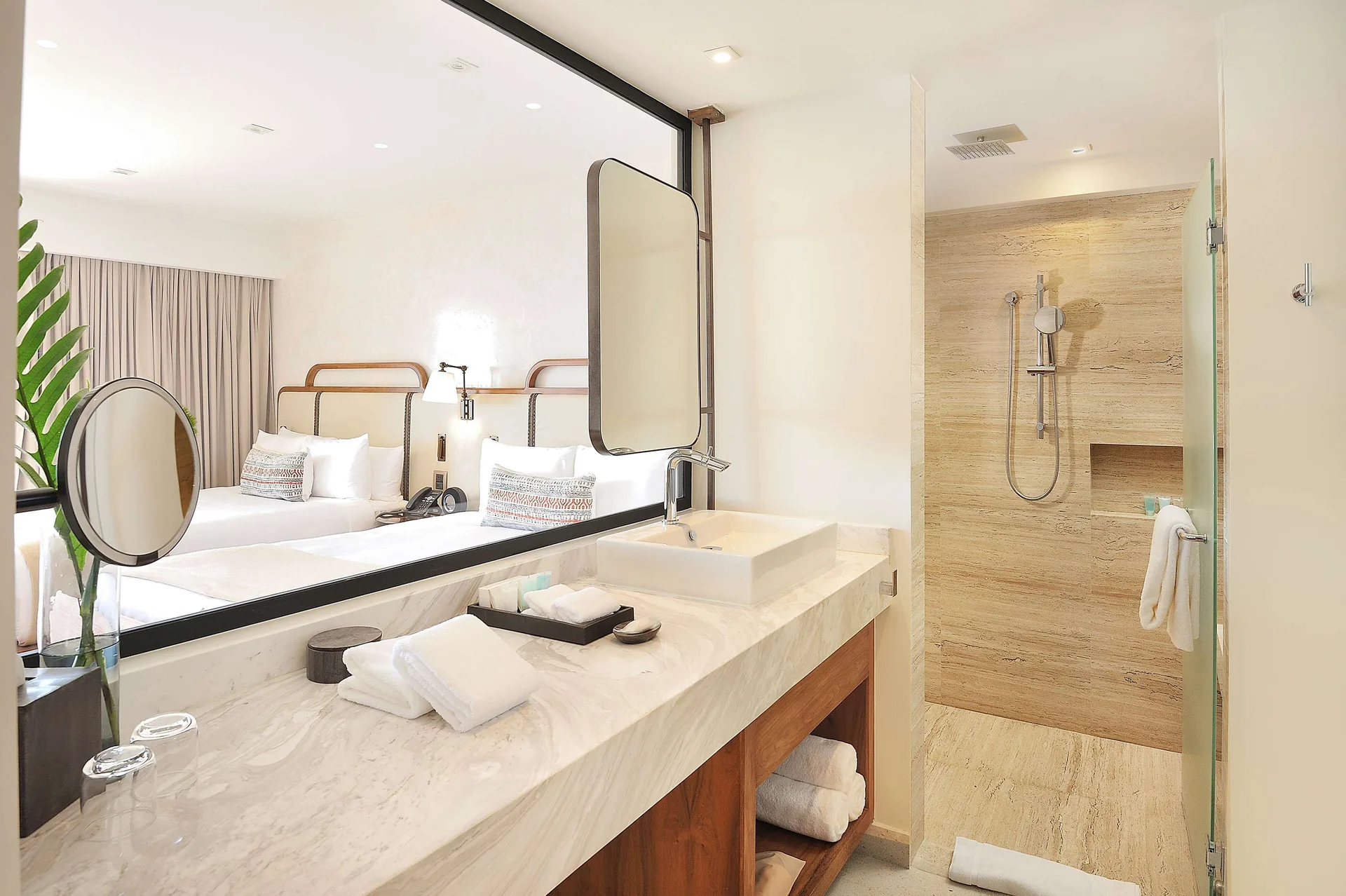 Infinity Sunset View room bathroom with vanity, shower, and beds reflected at Corazón Cabo.