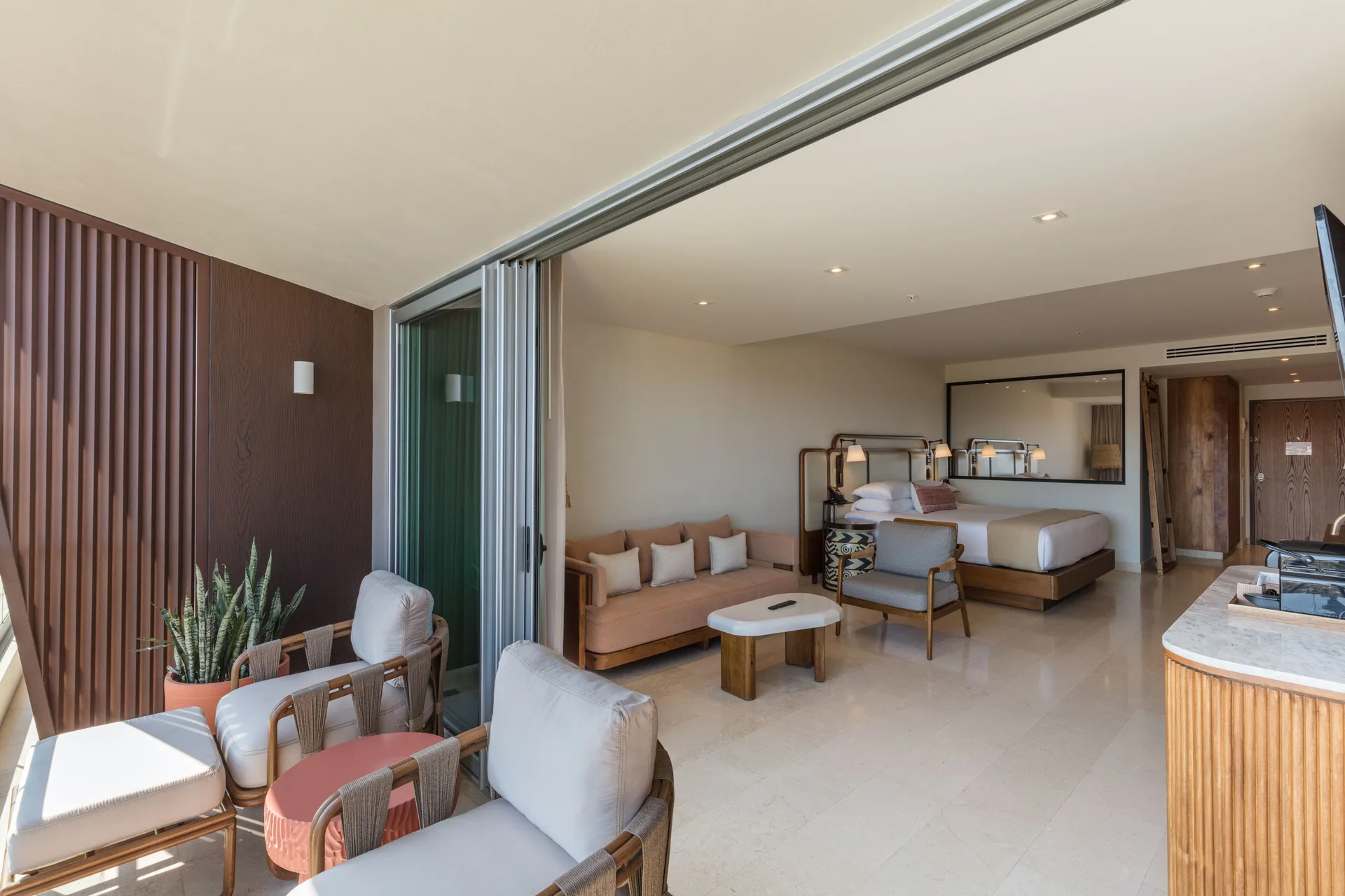 Infinity Sunset View room with balcony seating and indoor lounge area at Corazón Cabo.
