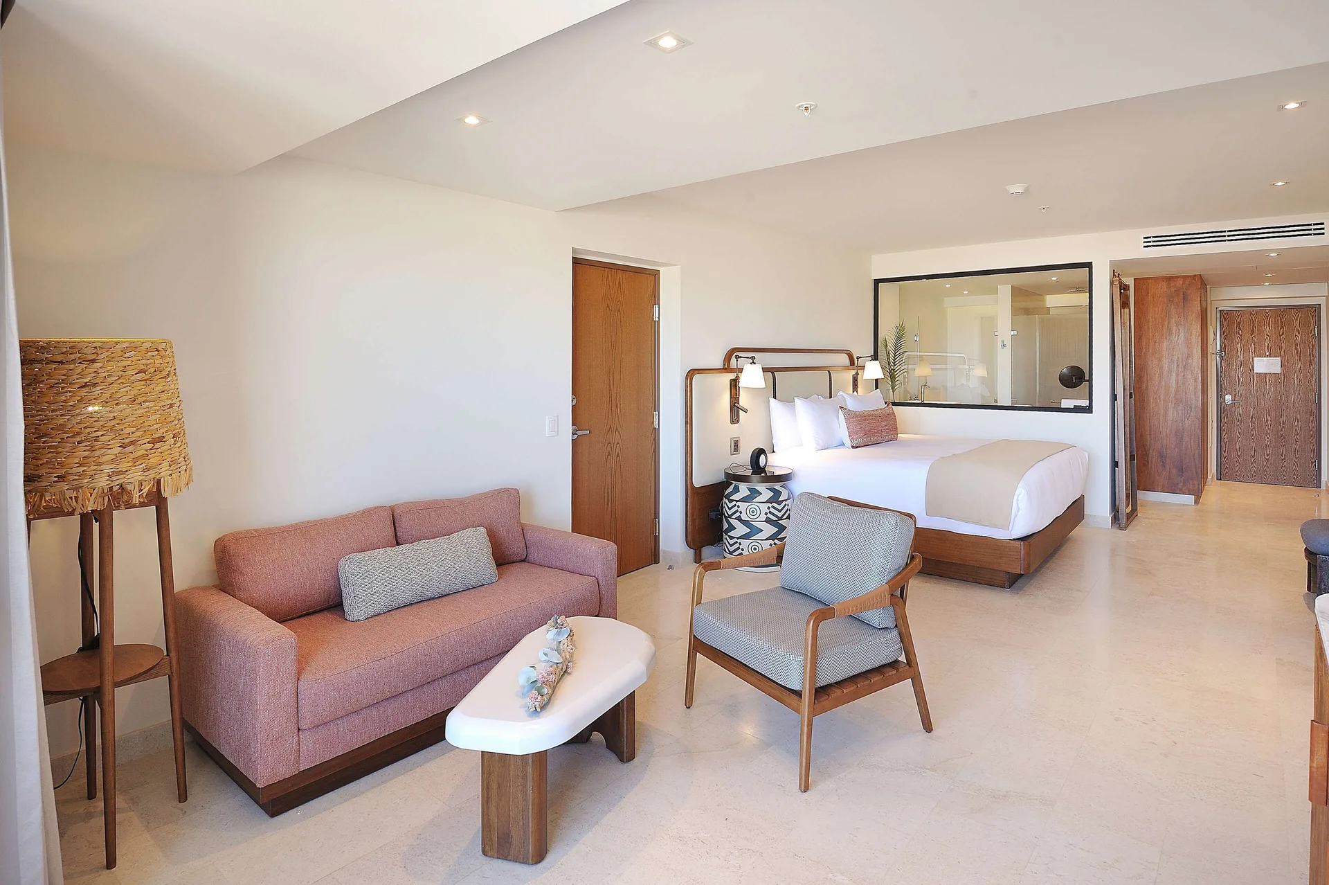 Infinity Sunset View king room with sofa, chair, and entry area at Corazón Cabo.
