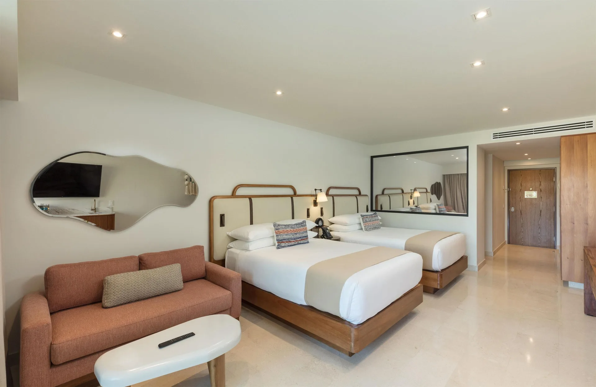 Infinity Sunset View room with two beds and sofa seating at Corazón Cabo.
