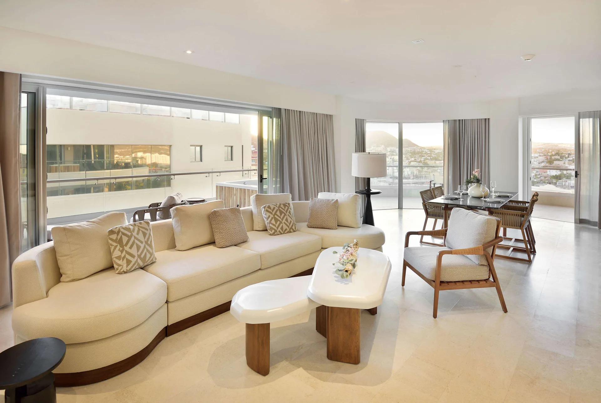Three-bedroom suite living and dining area with balcony doors at Corazón Cabo.