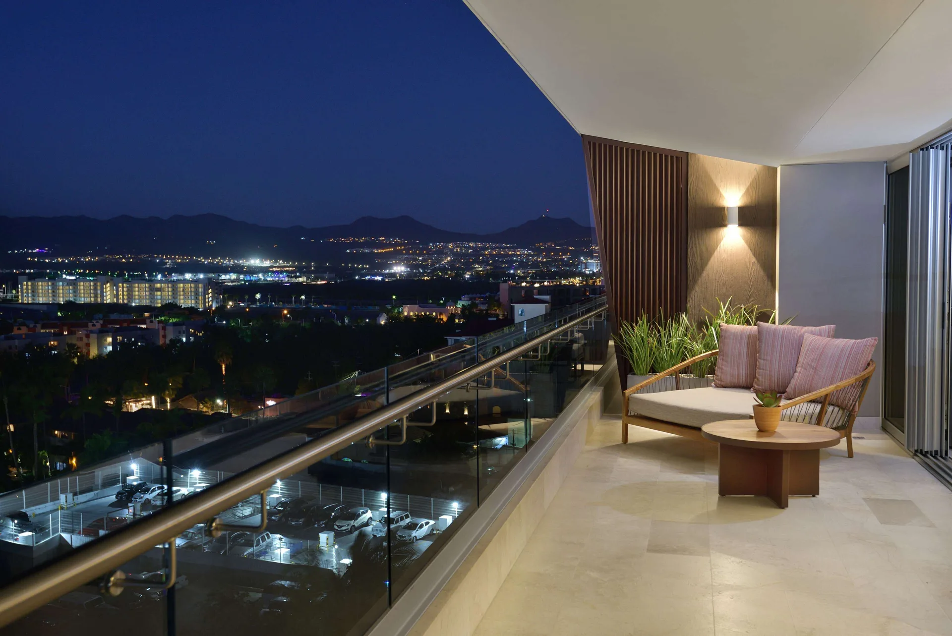 Three-bedroom suite balcony seating at night overlooking city lights at Corazón Cabo.