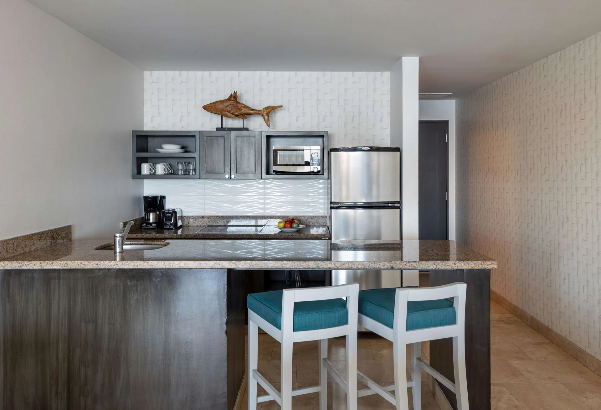 Three-bedroom suite kitchenette with bar seating at Corazón Cabo.
