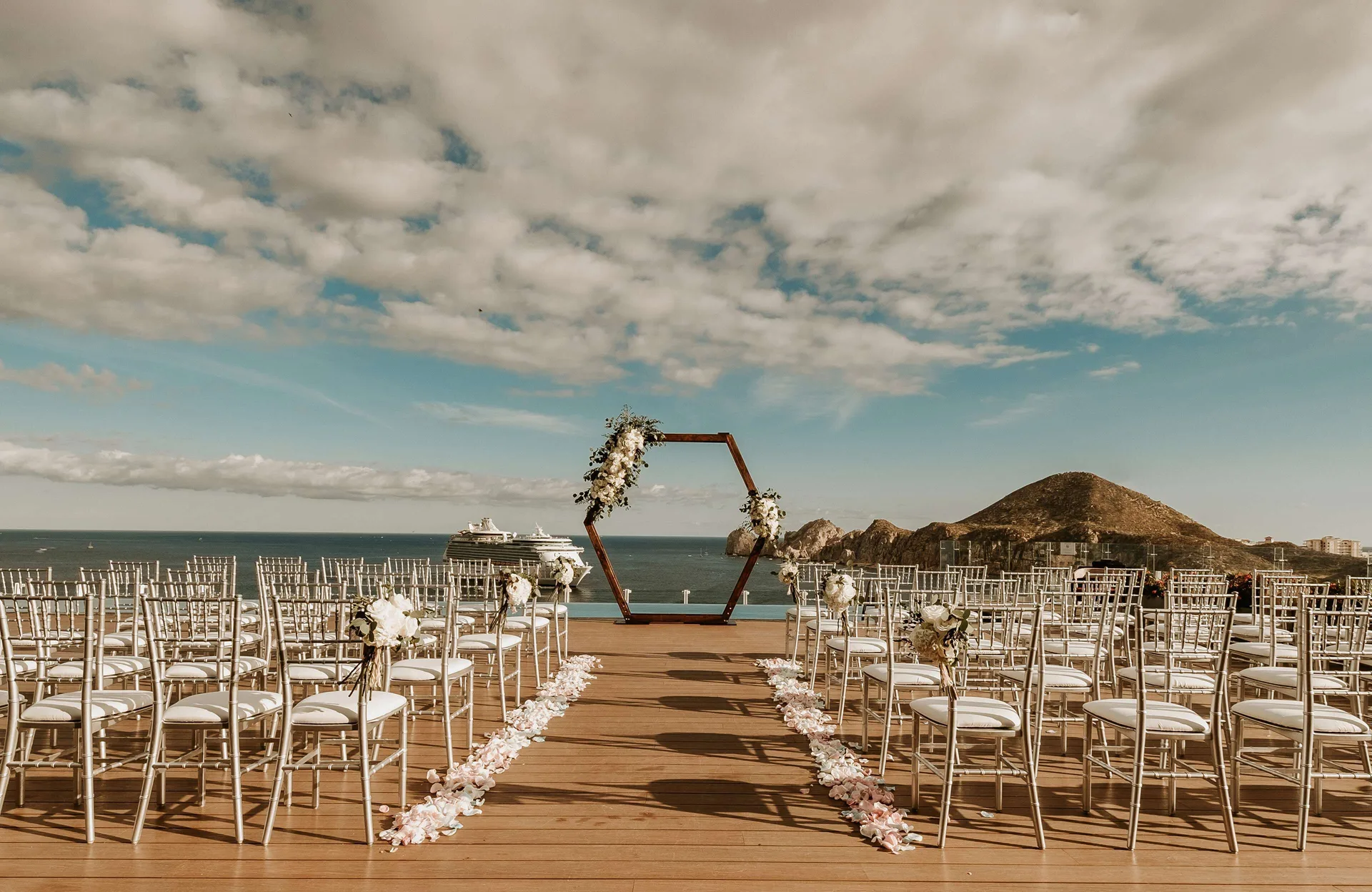 Ocean-view wedding ceremony aisle with white chairs at Corazón Cabo.