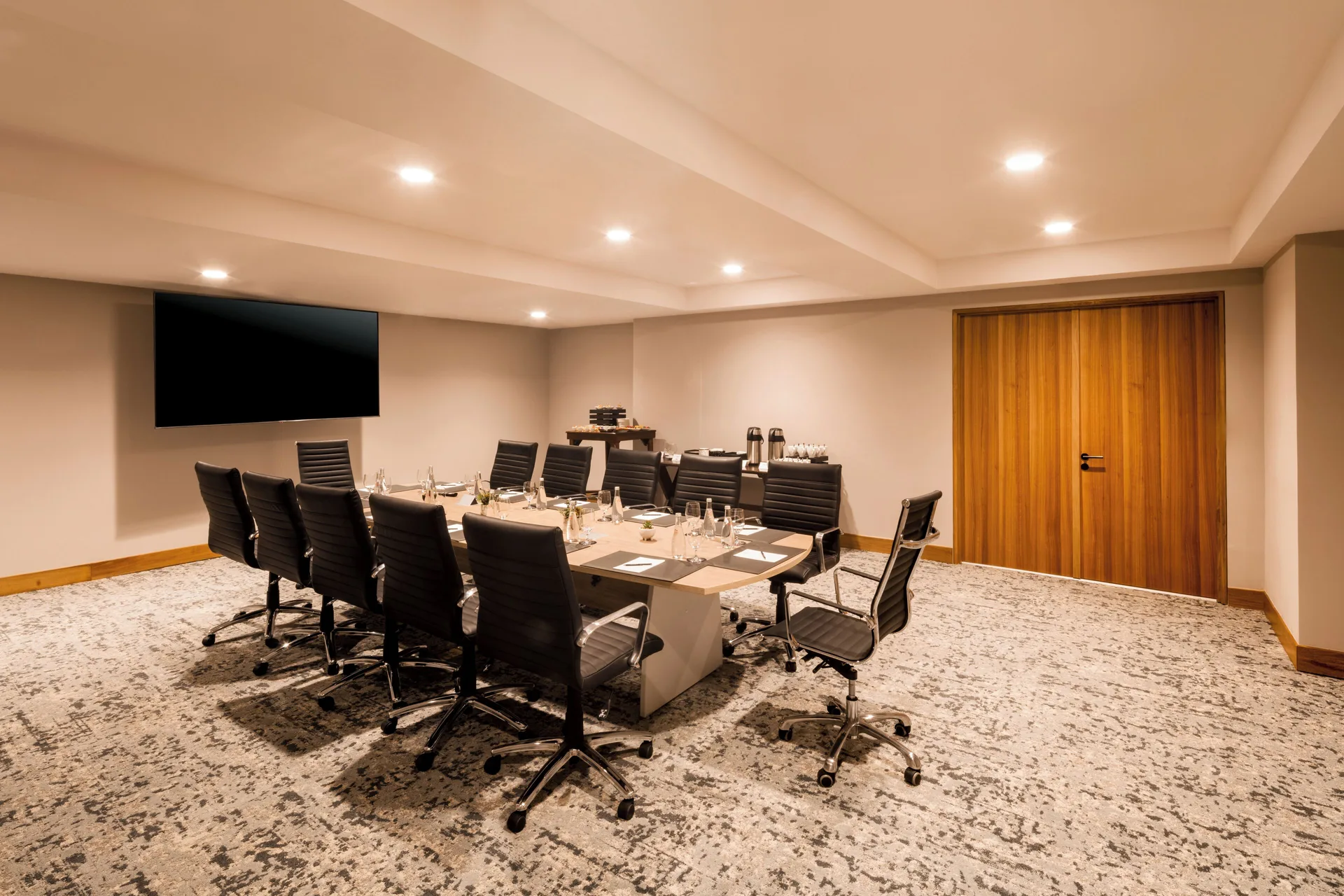 Private boardroom with conference chairs and a wall screen at Corazón Cabo.