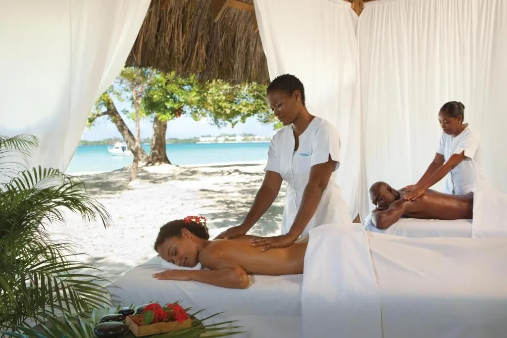 Beachfront massage cabana with two couples receiving treatments at Couples Negril.