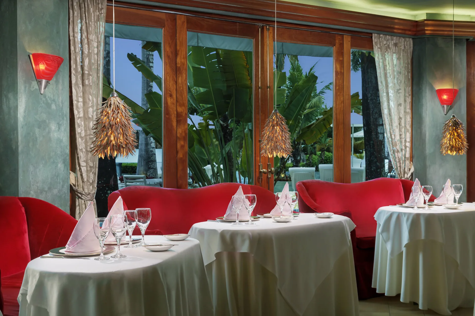 Elegant dining room with red sofas and white table settings at Couples Negril.