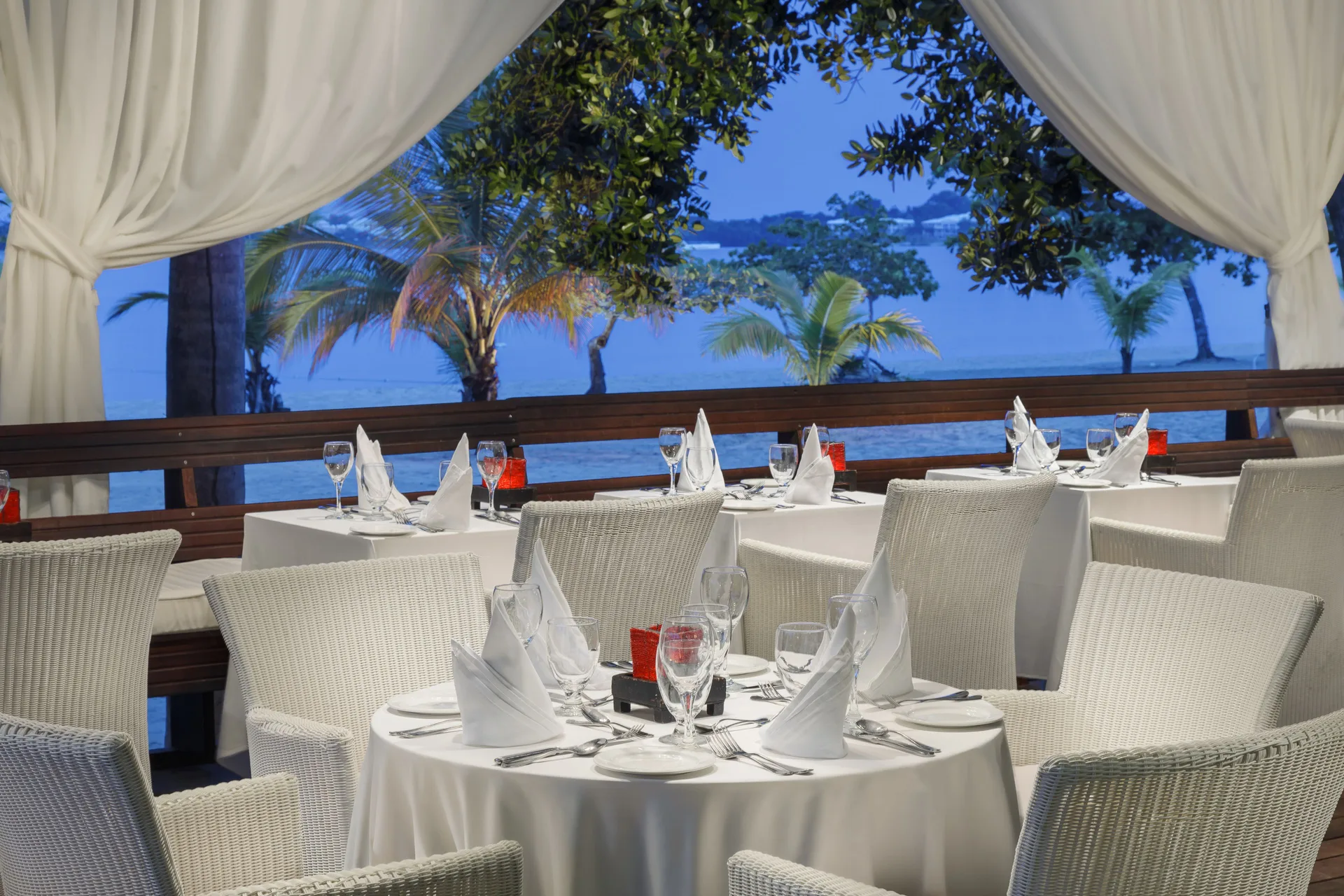 Open-air dining tables overlook the beach and water at Couples Negril.