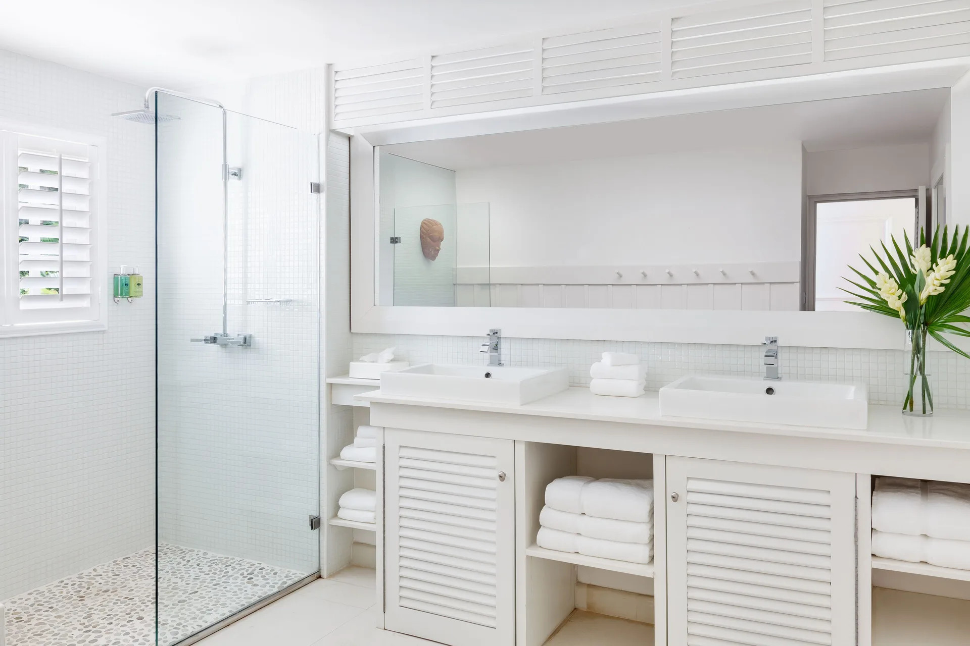 Beach Front Suite bathroom with double sinks and glass shower at Couples Sans Souci.