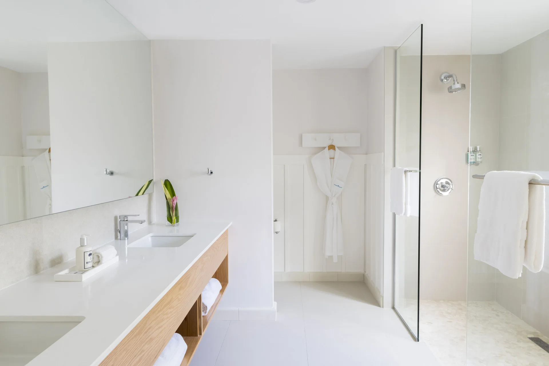 Deluxe Garden Suite bathroom with vanity and glass shower at Couples Sans Souci.