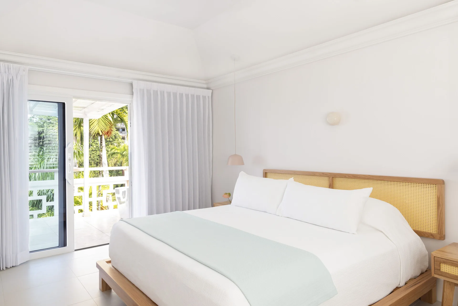 Penthouse Ocean Suite king bed and balcony doors at Couples Sans Souci.