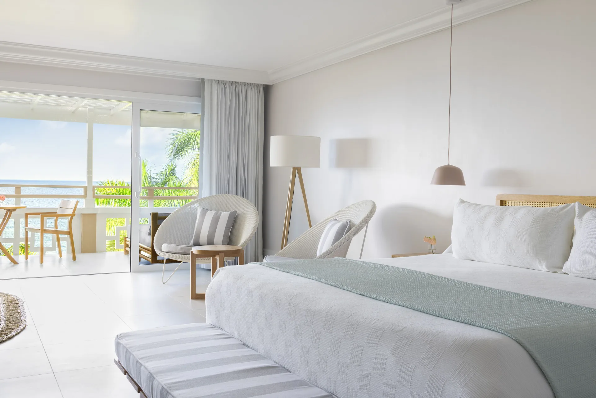 Premier Ocean Suite king bed and balcony view at Couples Sans Souci.