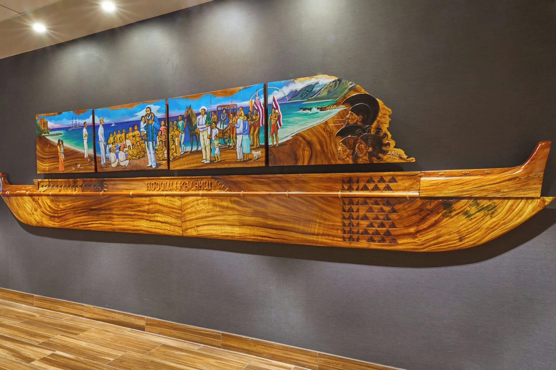 Carved canoe wall art and mural display at Courtyard Oahu North Shore.
