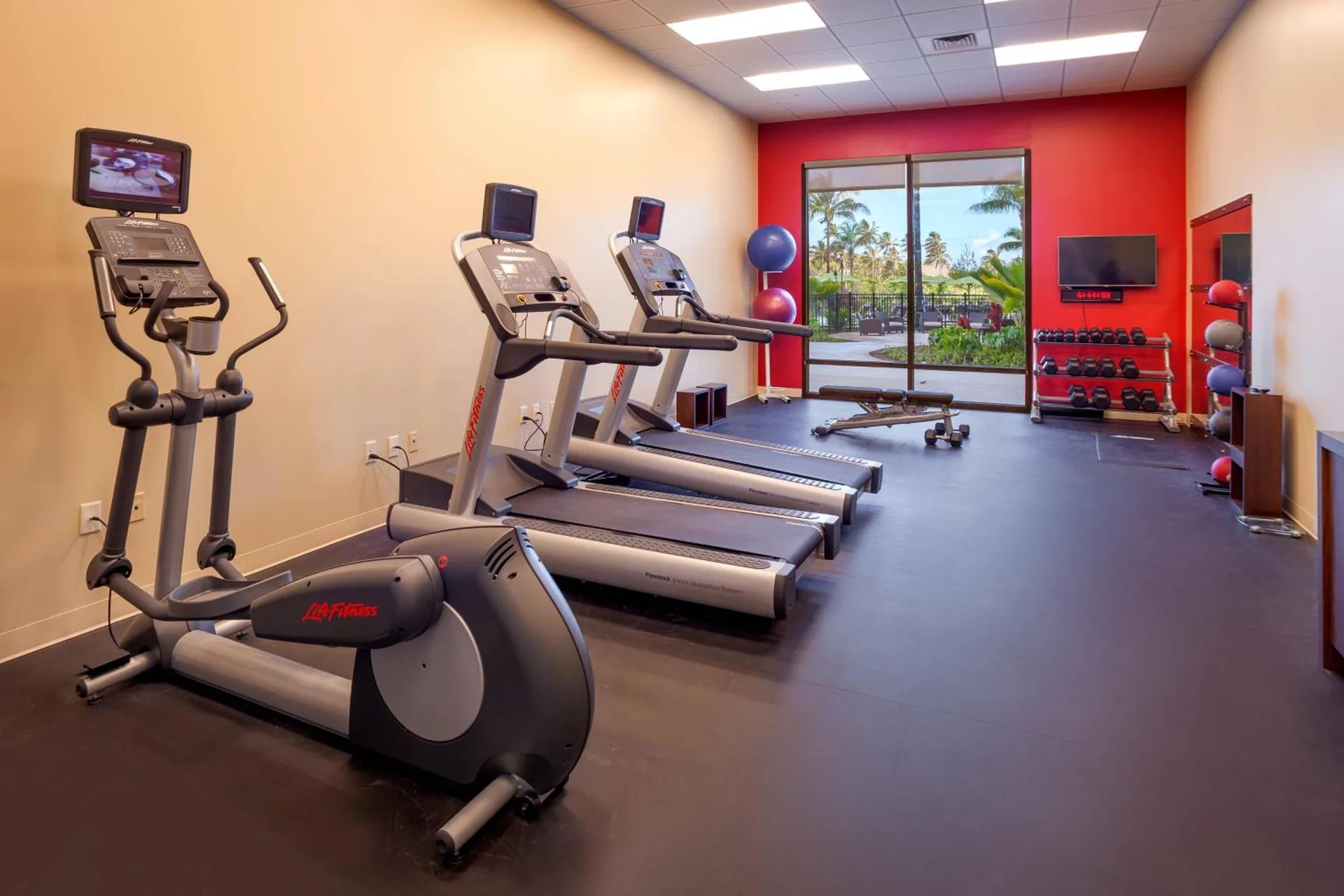 Fitness center with cardio machines and free weights at Courtyard Oahu North Shore.
