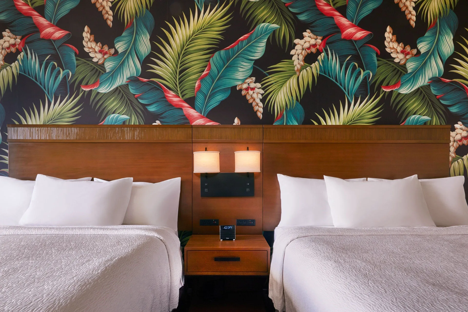 Two beds with shared nightstand at Courtyard Oahu North Shore.
