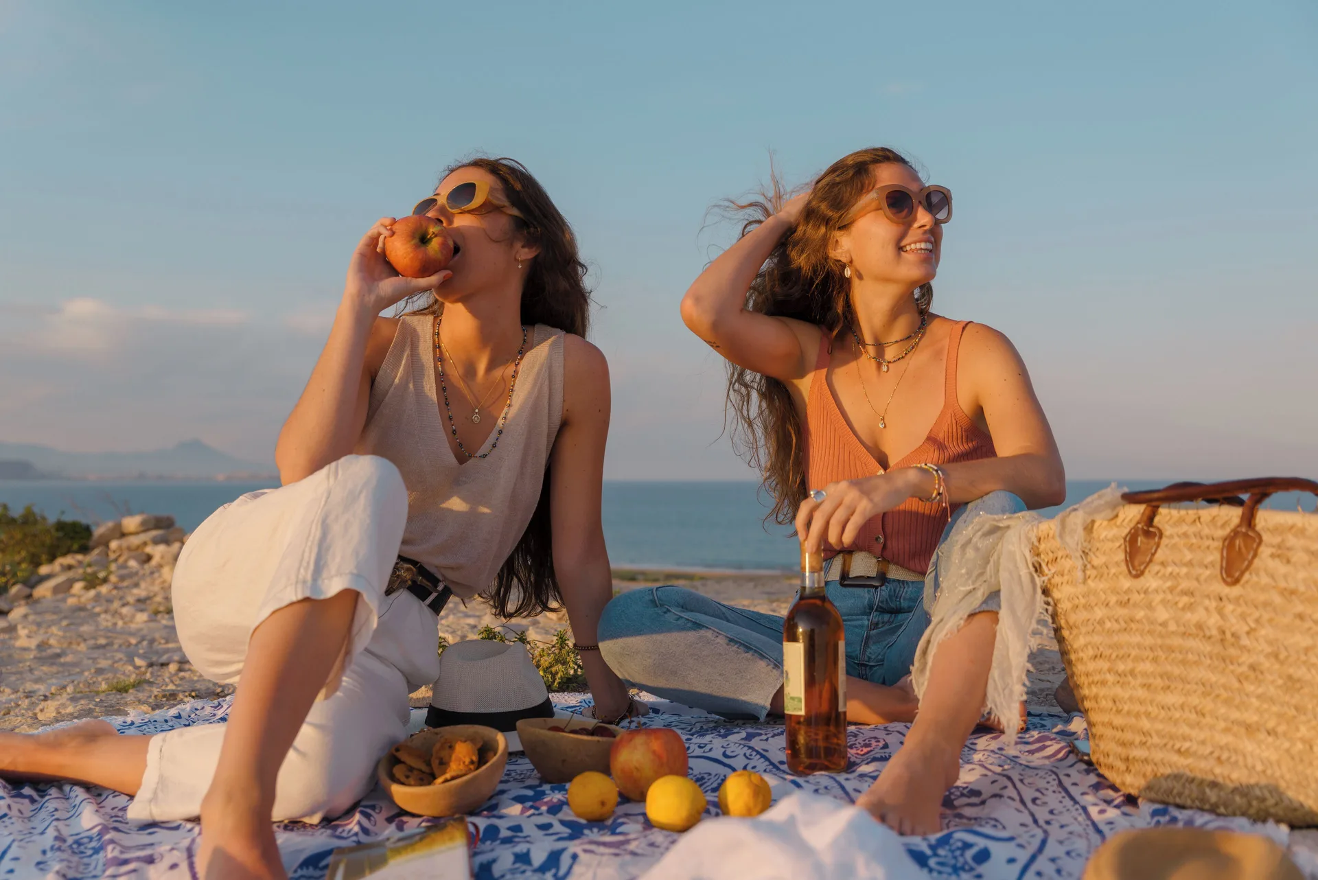 Two people picnic by the ocean near Courtyard Oahu North Shore.