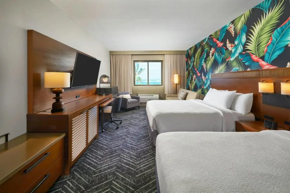 Hearing accessible sofa bed room with two beds at Courtyard Oahu North Shore.