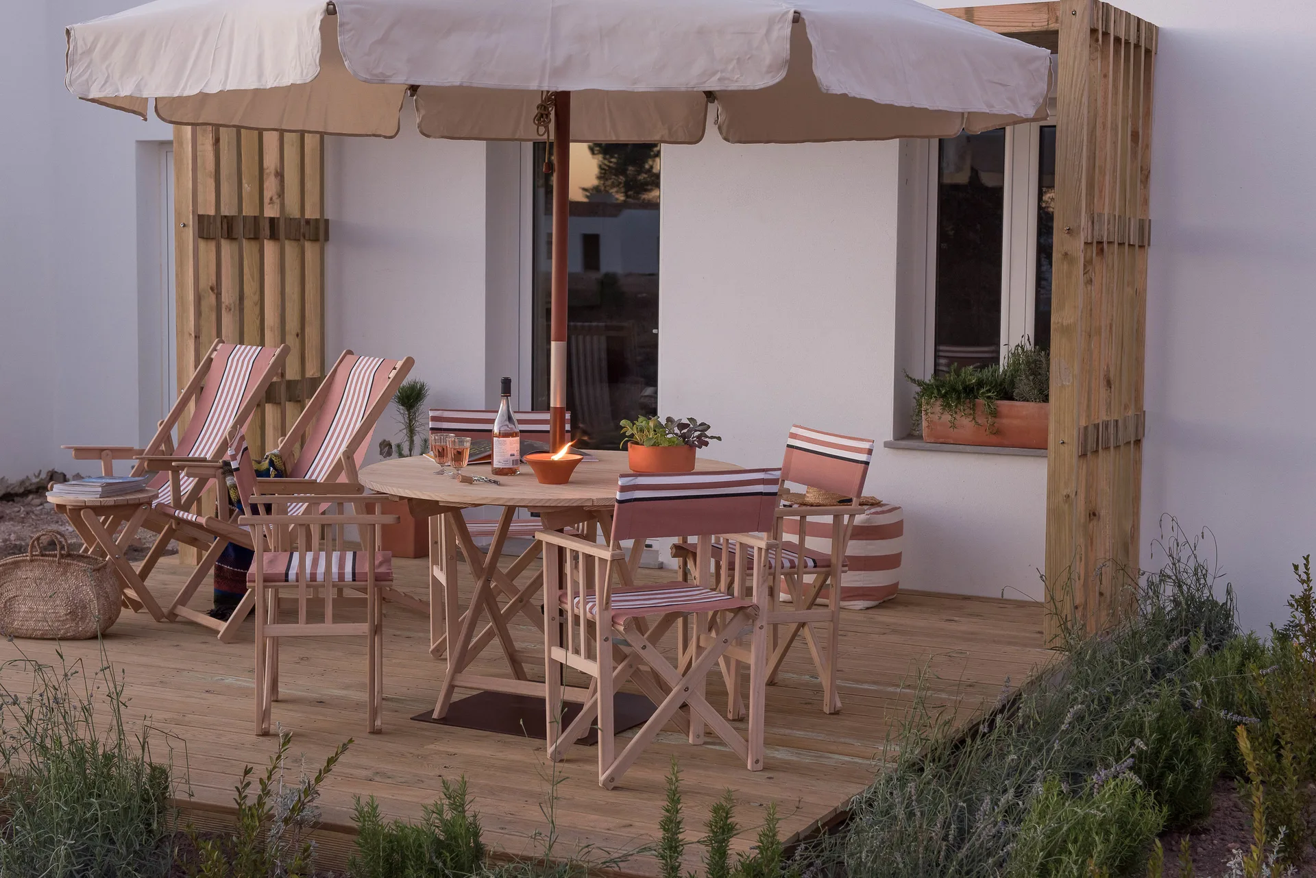 House 2 Bedrooms terrace with striped chairs and umbrella at Craveiral Farmhouse.