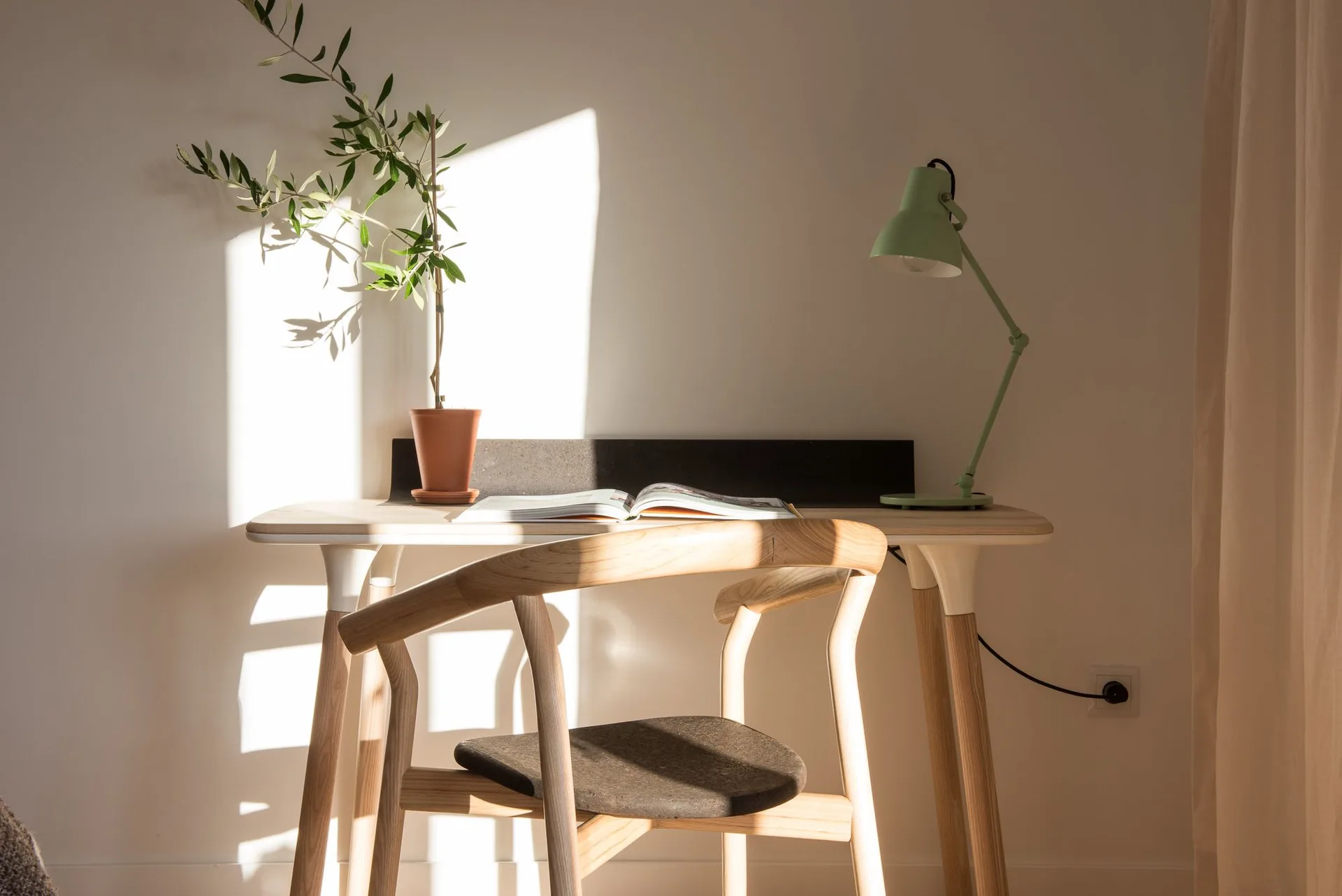 Studio desk with chair, plant and reading lamp at Craveiral Farmhouse.