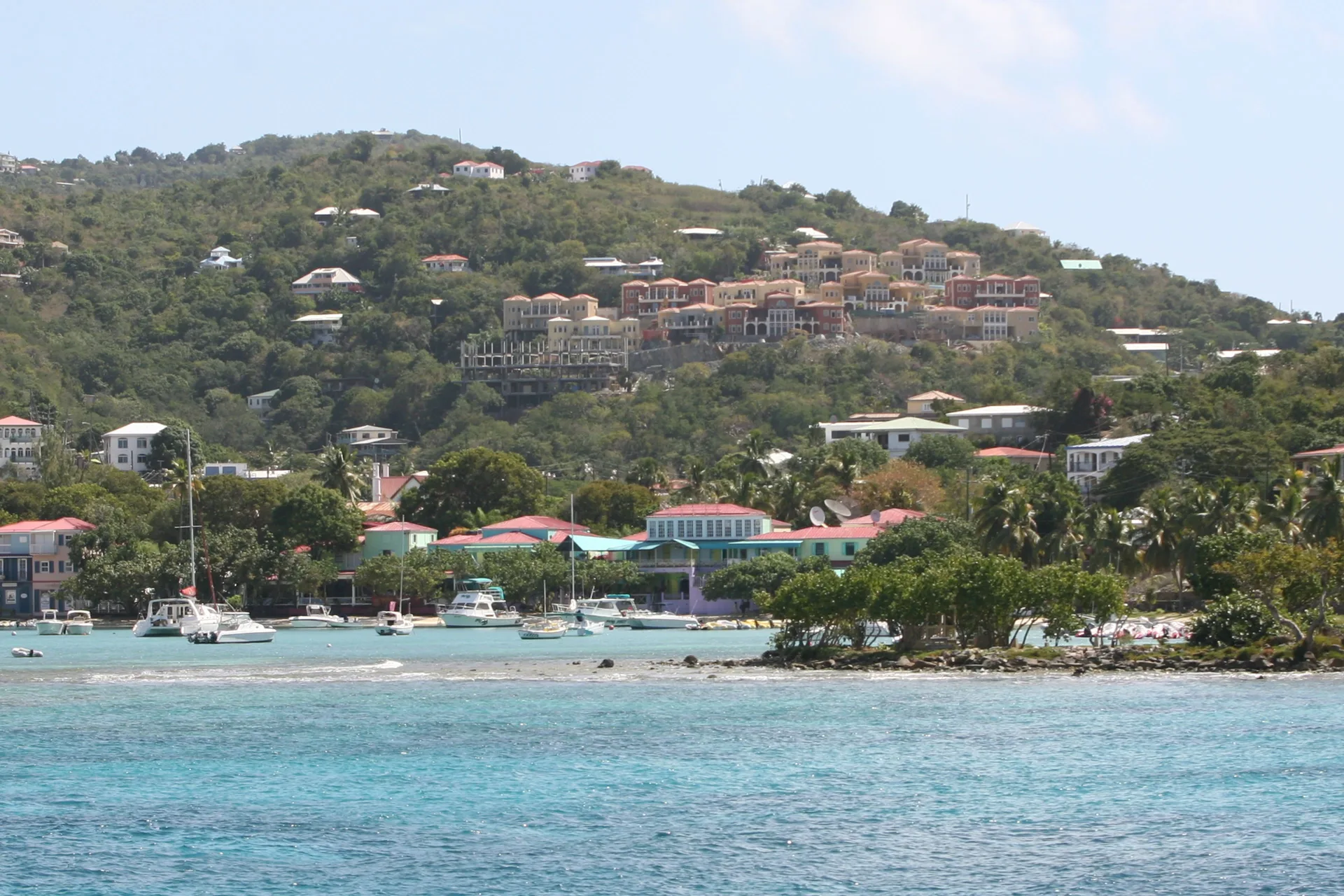Coastal hillside and anchored boats across the water near Cruz Bay Boutique Hotel.