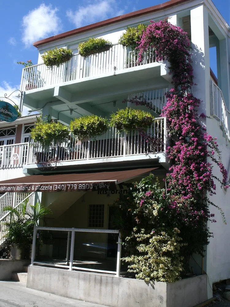 Exterior balconies and flowering vines at Cruz Bay Boutique Hotel.