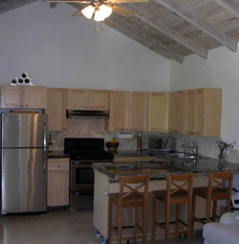 Kitchen with island seating and wood cabinets at Cruz Bay Boutique Hotel.
